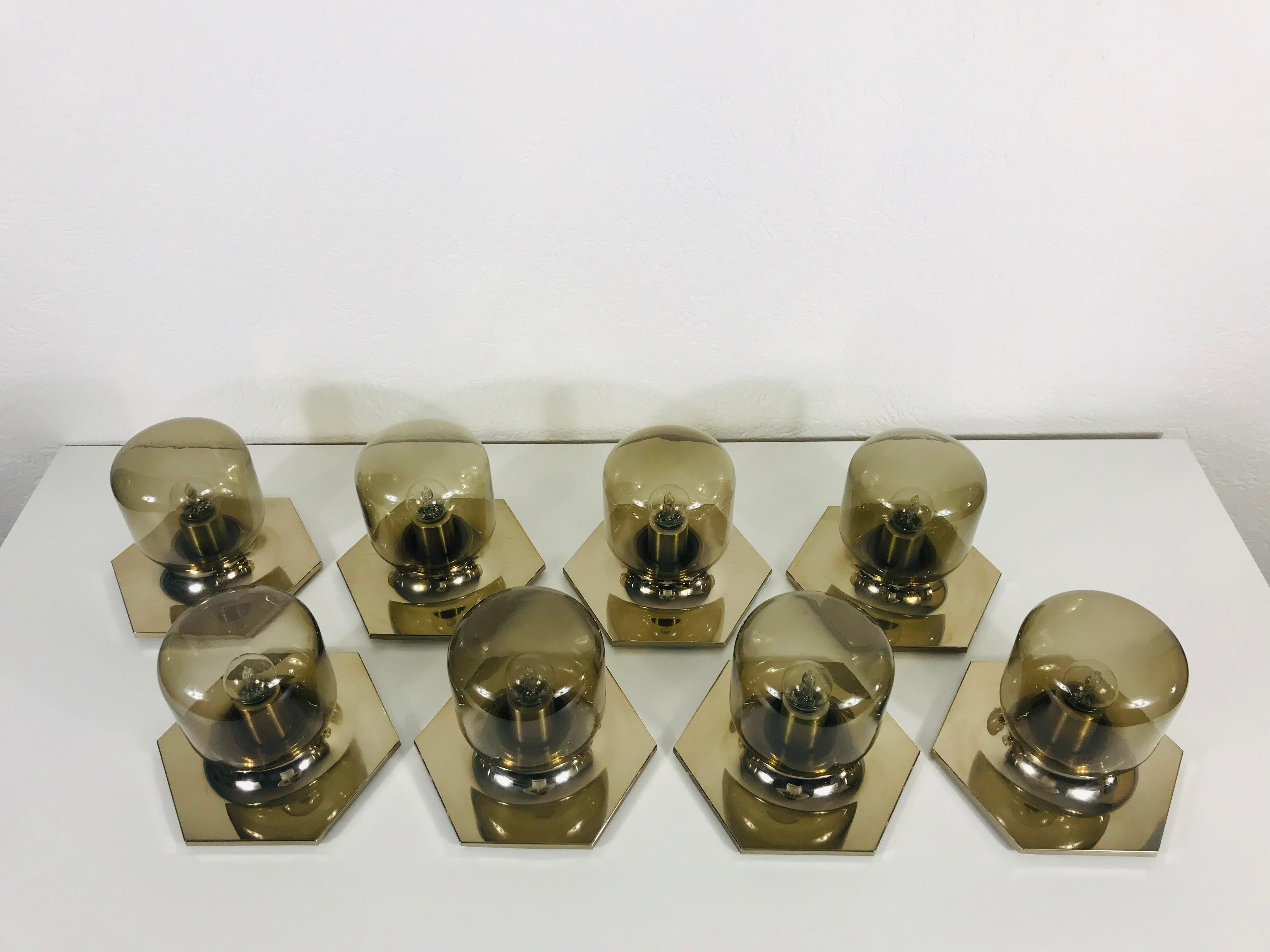 A wonderful set of 8 wall or ceiling lights by the Japanese designer Motoko Ishii for the German brand Staff Leuchten. They have a very thin amber glass shade and a brass base.