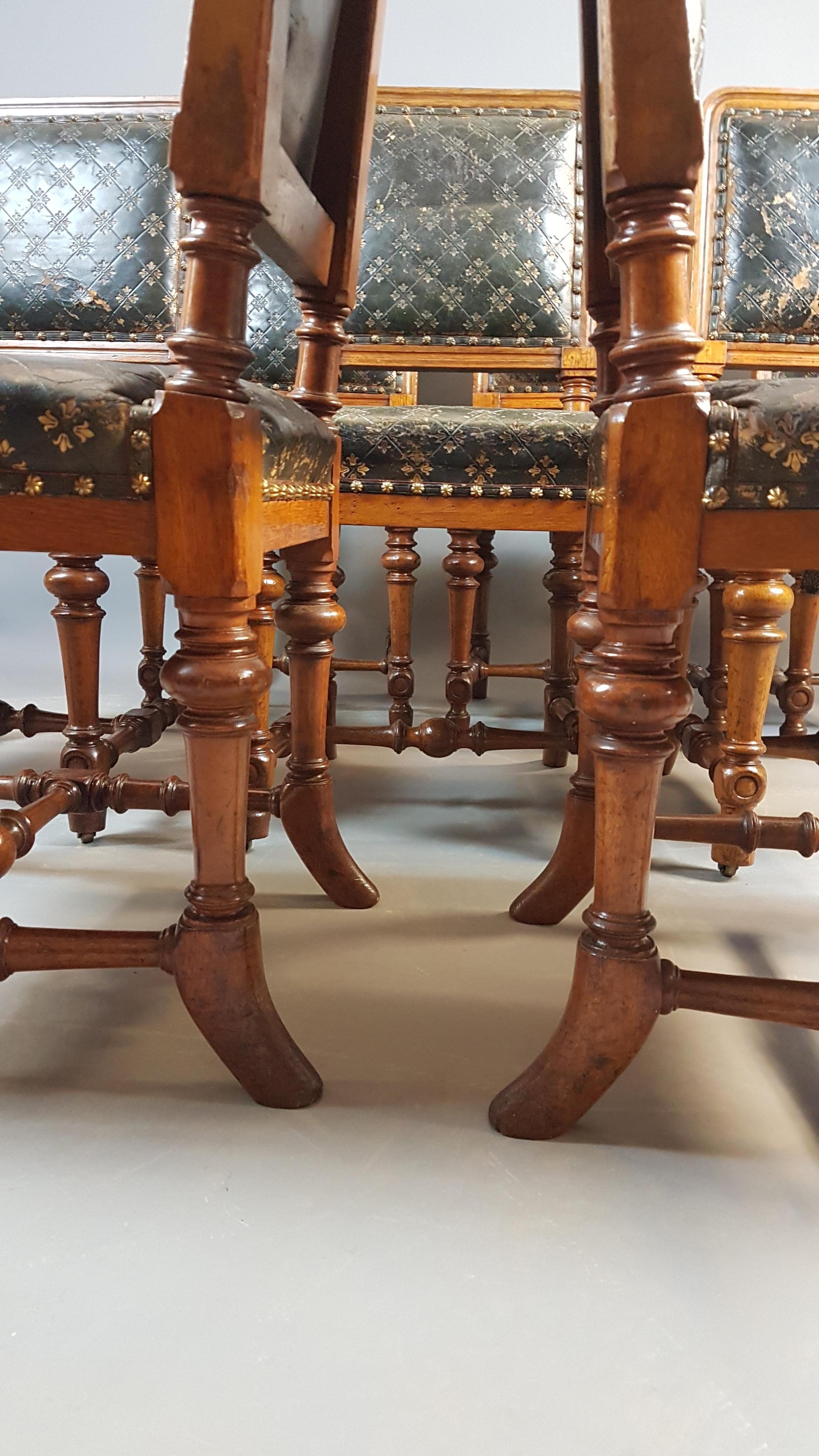A very beautiful and exceptionally rare set of 8 oak dining chairs in their original embossed leather setting and stamped Holland and Sons. The chairs retain their original golden oak finish which is in very good condition, each front leg contains a