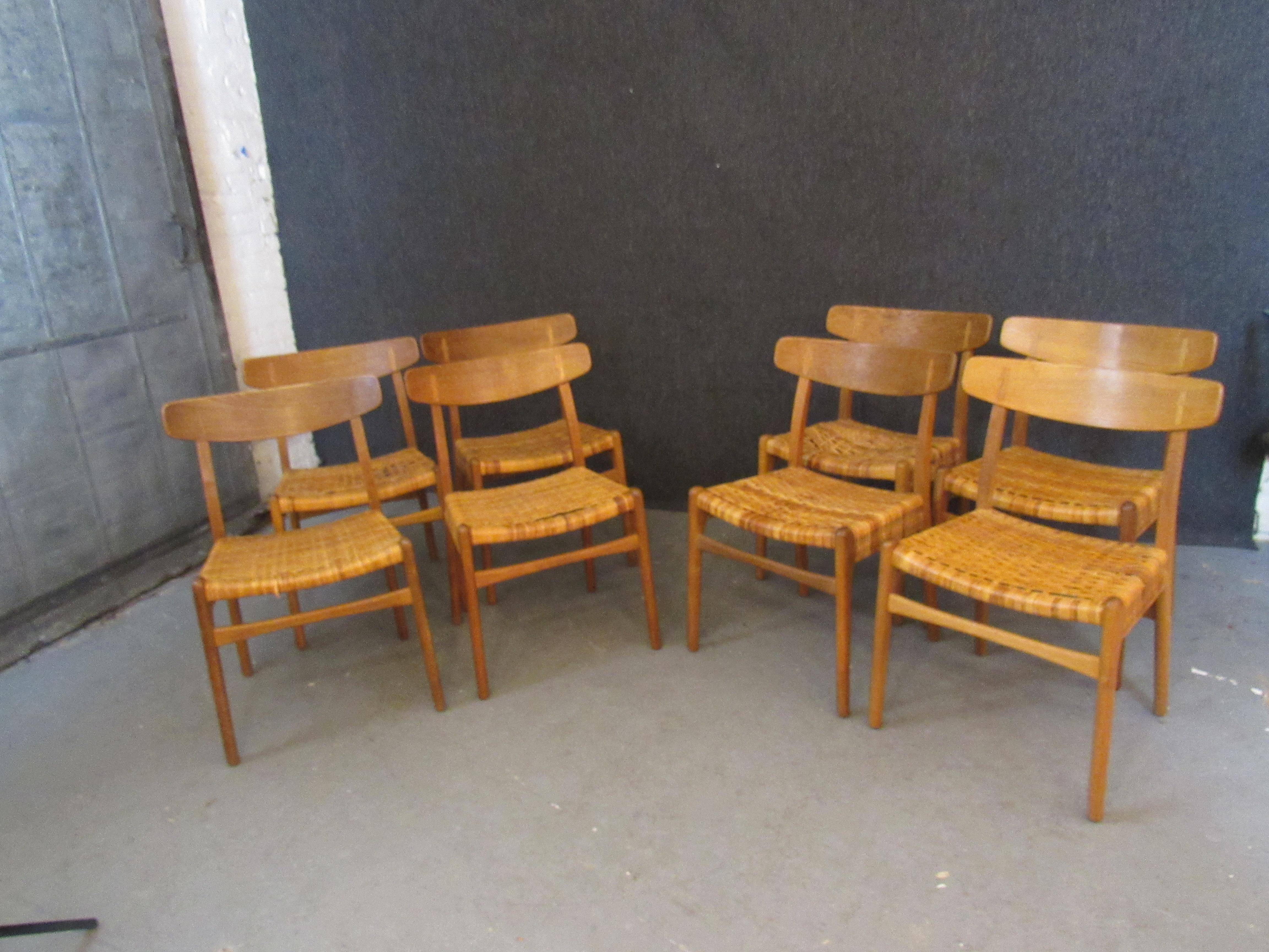 Bring home the authentic mid-century modern Danish furniture that has become the envy of the design world with this exquisite set of original Hans Wegner CH-23 oak & rattan dining chairs. A lovely oak wood grain is highlighted with a satin oil