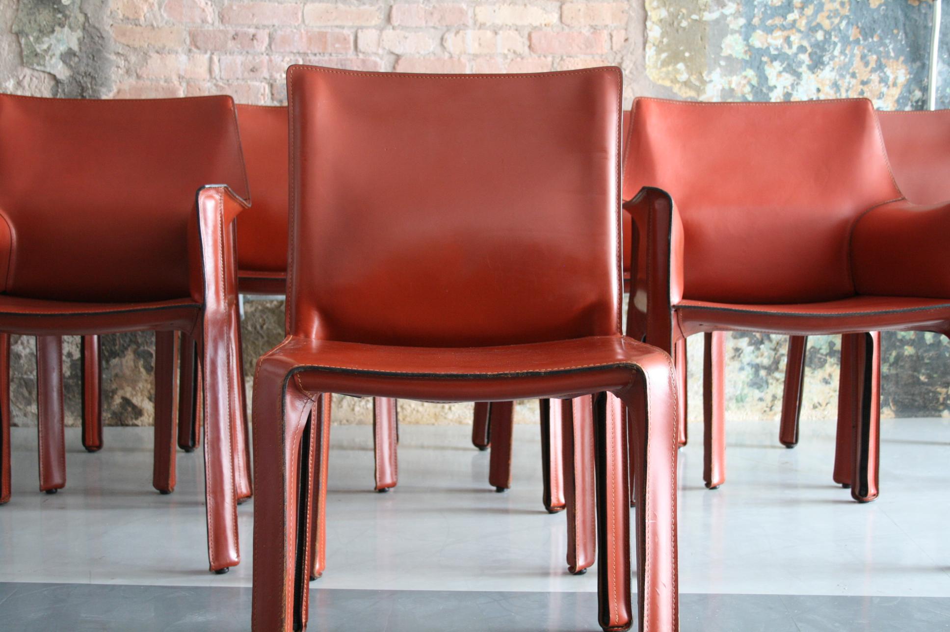 A beautiful set of 8 (2 arm chairs and 6 side chairs) All of them are in fantastic condition with a beautiful rich patina to the red leather. These are an original design by Mario Bellini for Cassina Italy.