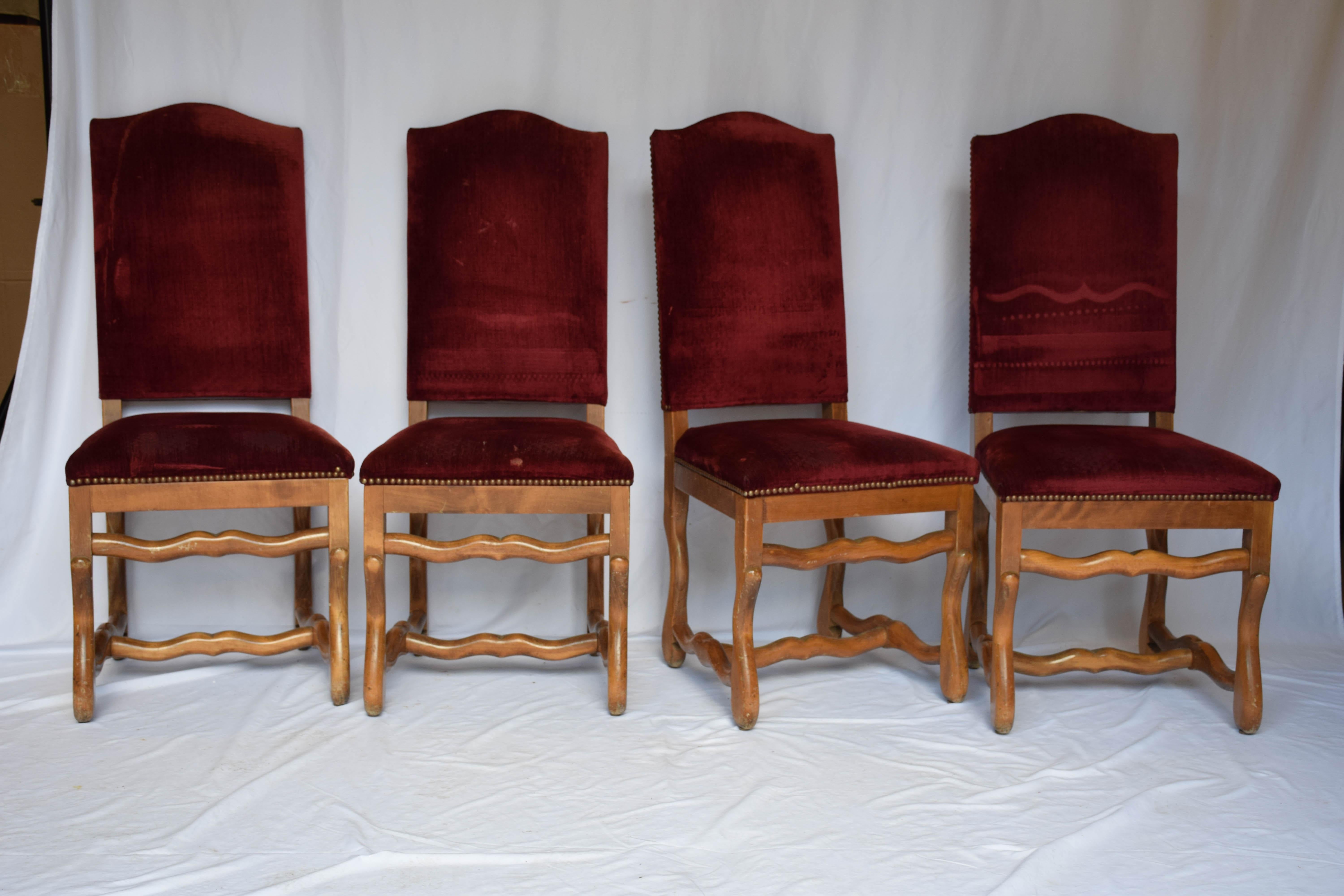 This set of Os de Mouton chairs ( French for sheep bone) is upholstered in a red velvet. The curved wood legs and arms are in a honey stained finish and are in the style of the Louis XIV period. They would make a beautiful addition to any dining