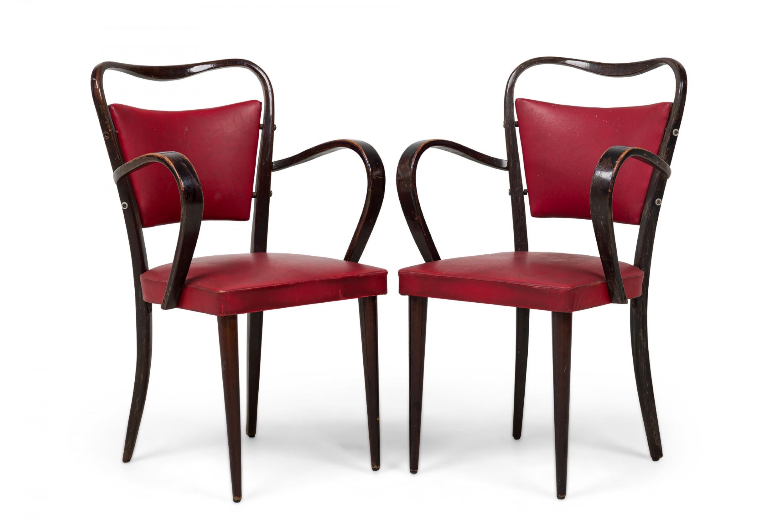 Set di 8 poltrone in noce con finitura marrone scuro, con struttura sagomata e schienali e sedute imbottiti in vinile rosso, che poggiano su gambe anteriori affusolate e gambe posteriori distanziate. (PREZZO COME SET) (Paolo Buffa)

Usura e