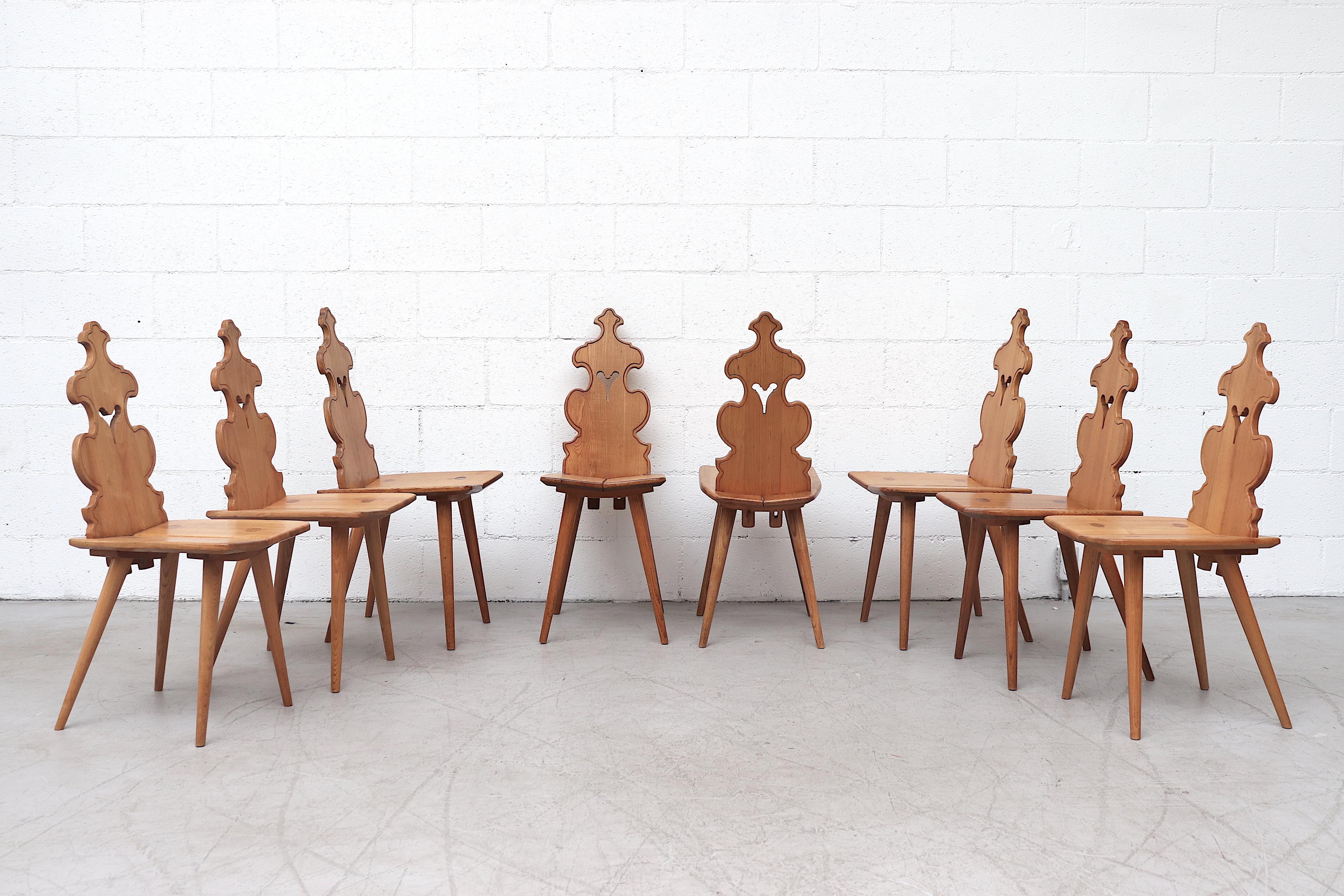 Incredible set of 8 Austrian style pine dining chairs with beautiful decorative backrest and tapered pine legs. Lightly refinished highlighting their beautiful craftsmanship and striking design. In original condition with wear consistent with age