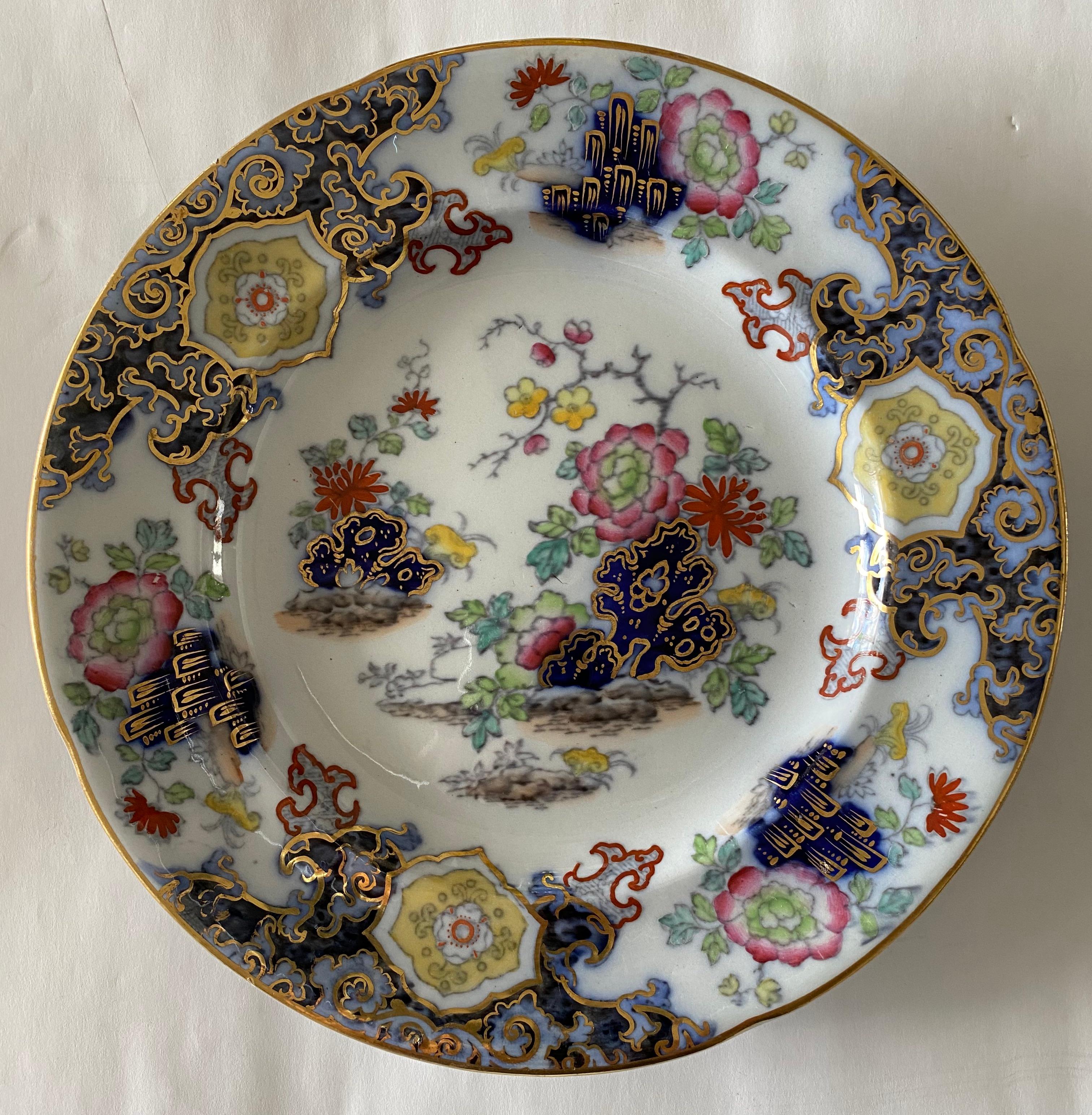 Set of 8 ironstone china plates in a flamboyent and colorful floral chinoiserie pattern with motifs of chrysanthemums and lotus flowers, cherry blossoms and peonies. The coloration includes gilt, rich blues, pinks, yellows and greens.

Rear marks