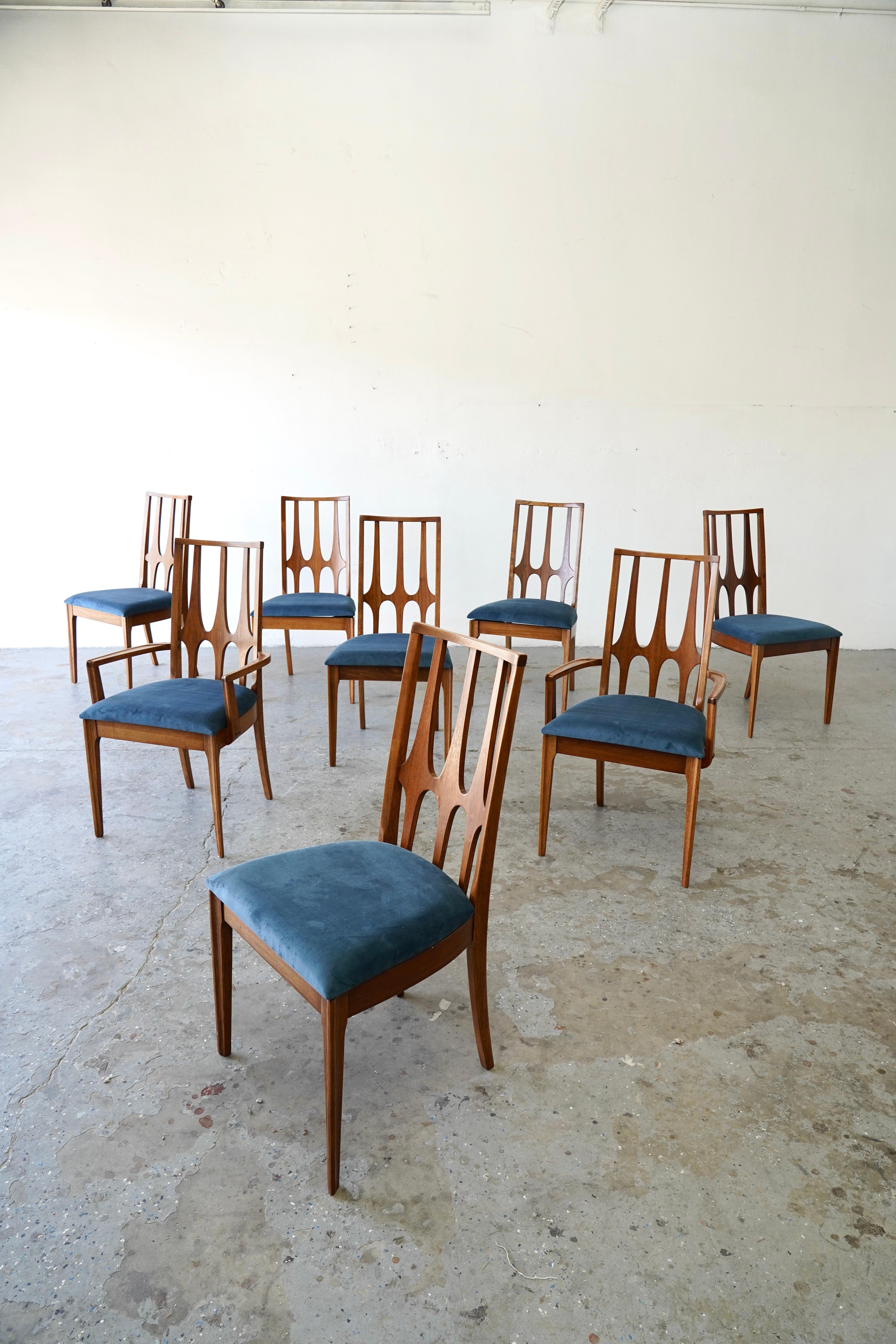 A beautifully restored set of eight walnut dining chairs from the iconic Brasilia collection by Broyhill, designed circa the 1960s and inspired by the architecture of Oscar Niemeyer. This highly sought-after American Mid-Century Modern line is