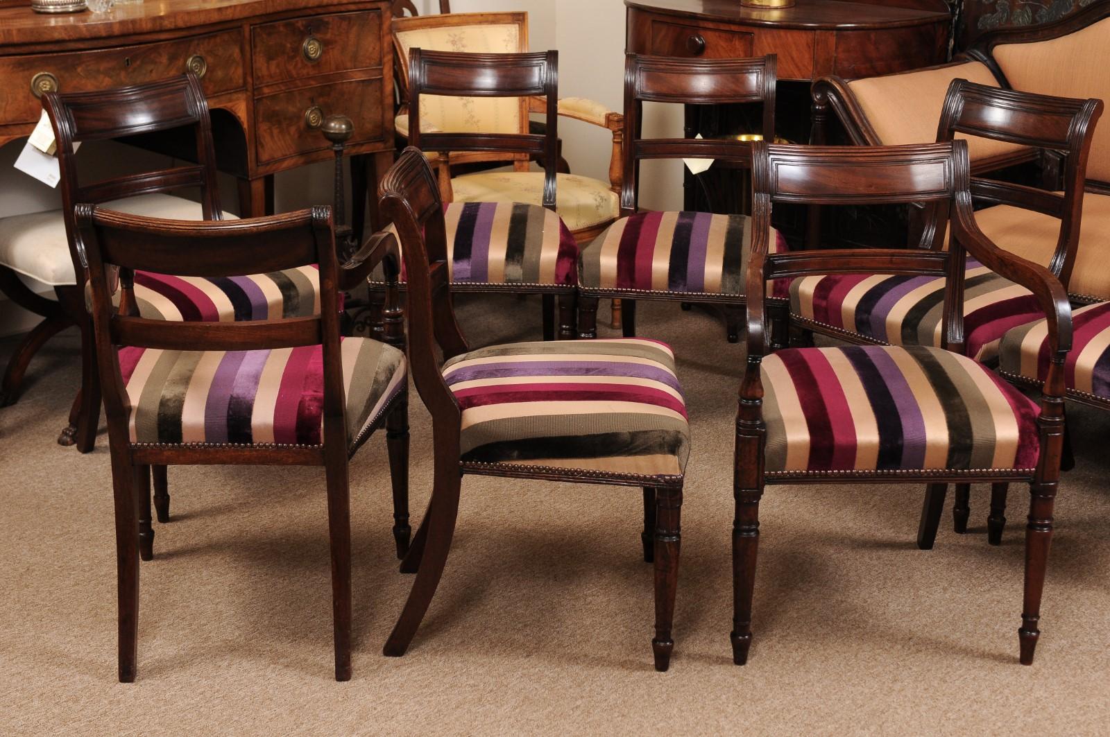 Set of 19th century English regency dining chairs in mahogany with turned front legs, splay rear legs, and reeded detail. Set includes two (2) arm chairs and six (6) side chairs.

Measures: sides 19