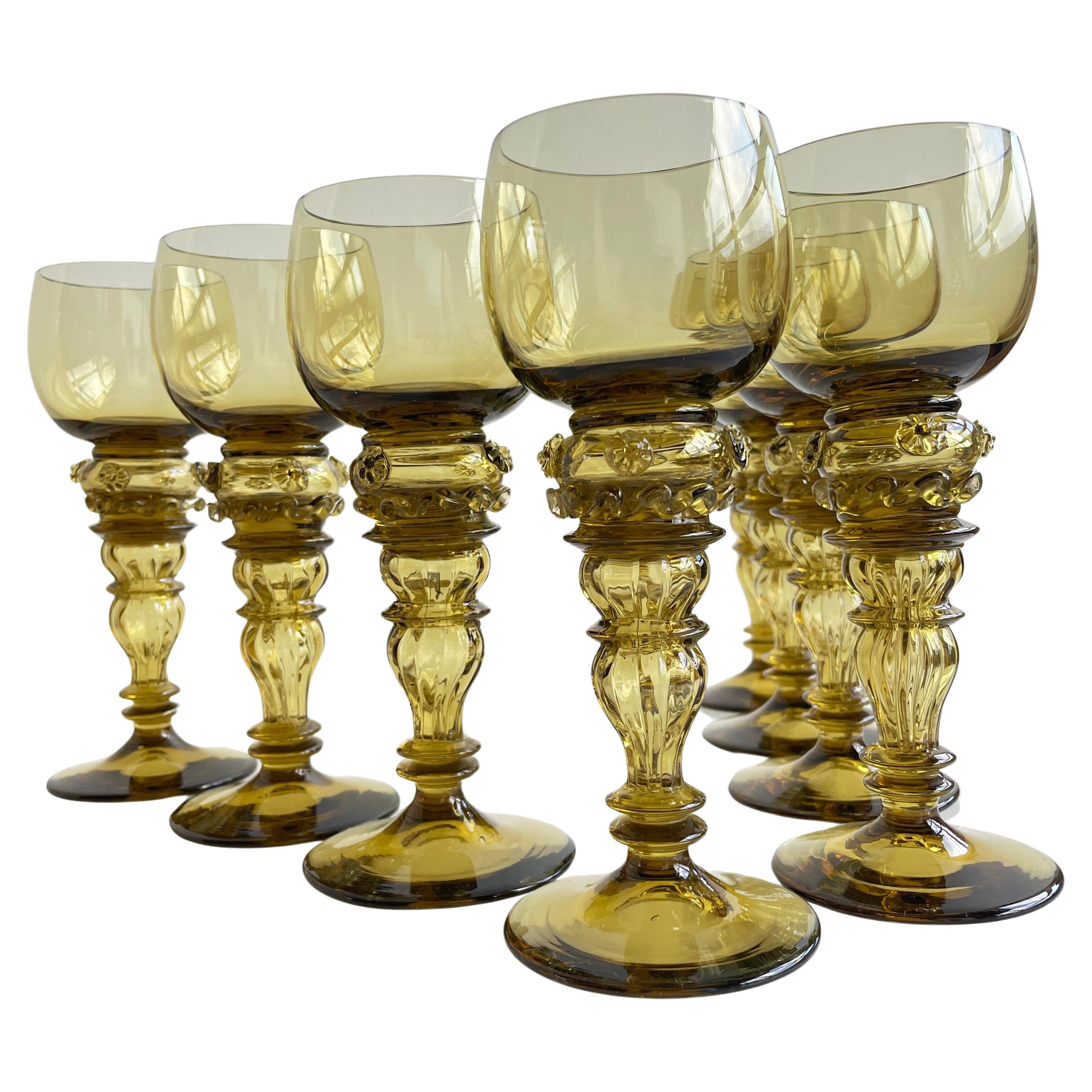 Set of 8 Römer Glass Goblets. Hand-blown crystal glass. Made by Theresienthal, Germany. Roemer wine glasses in a pale olive green colour. 
Baluster shaped stem. Bowl of glass decorated with vine leaves and bunch of grapes.
The set are in prime