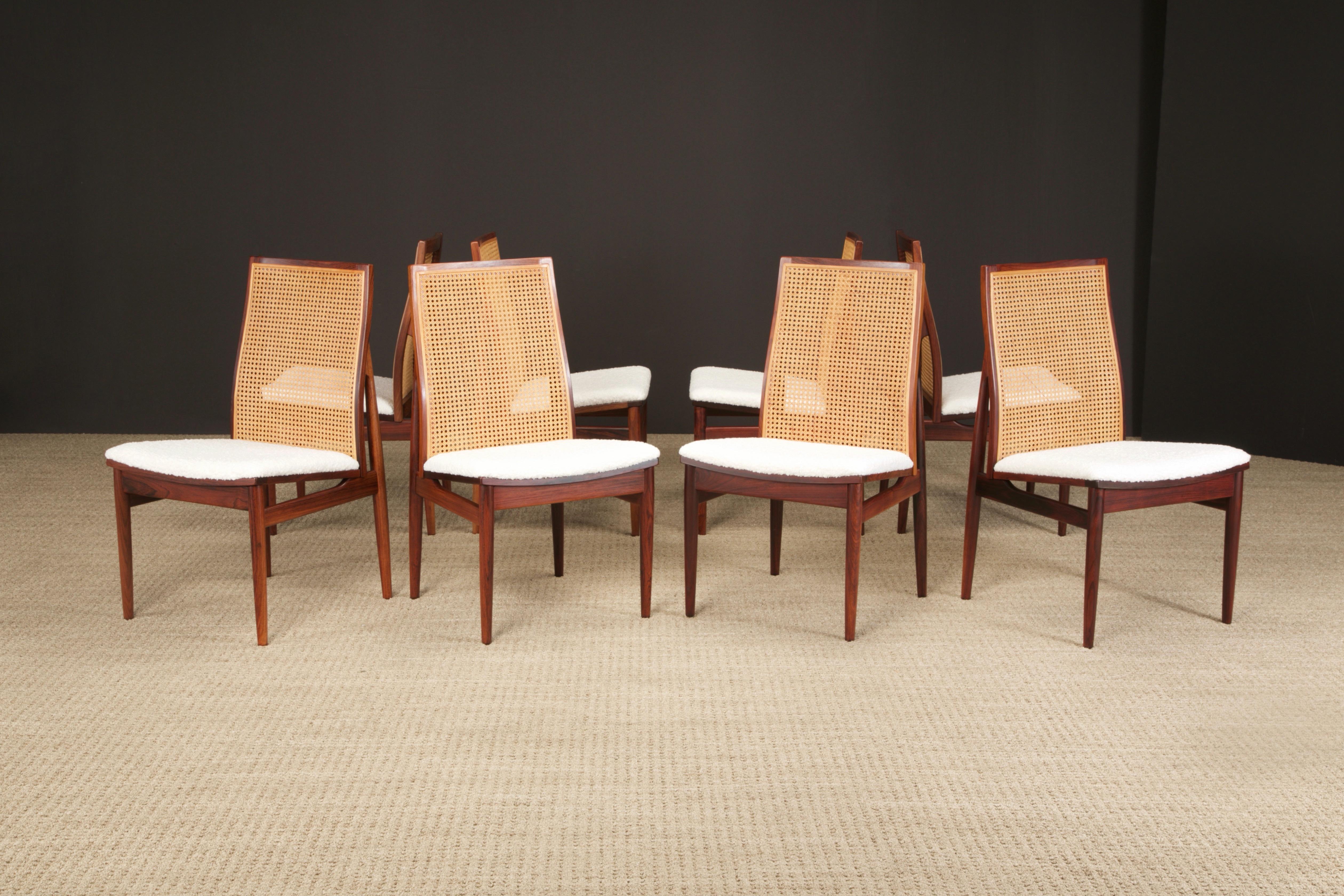 This incredible set of 8 dining chairs feature gorgeous deep grained Rosewood with caned seat backs and newly reupholstered bouclé seats. 

While these share many similarities with designs by Brazilian modernism designer Joaquim Tenreiro, this set