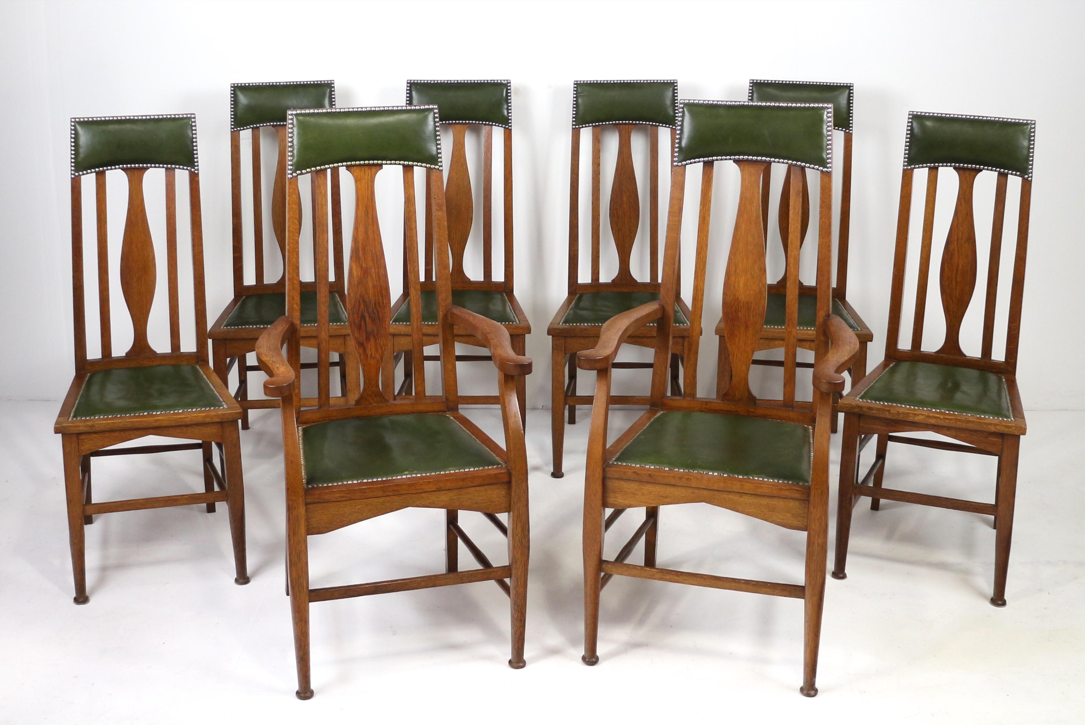 Un attraente set di otto sedie da pranzo con schienale alto in quercia dorata di Arts & Crafts attribuite a Ernest Archibald Taylor e probabilmente realizzate dalla nota ditta Wylie & Lochhead di Glasgow.  Composto da due poltrone e sei poltrone