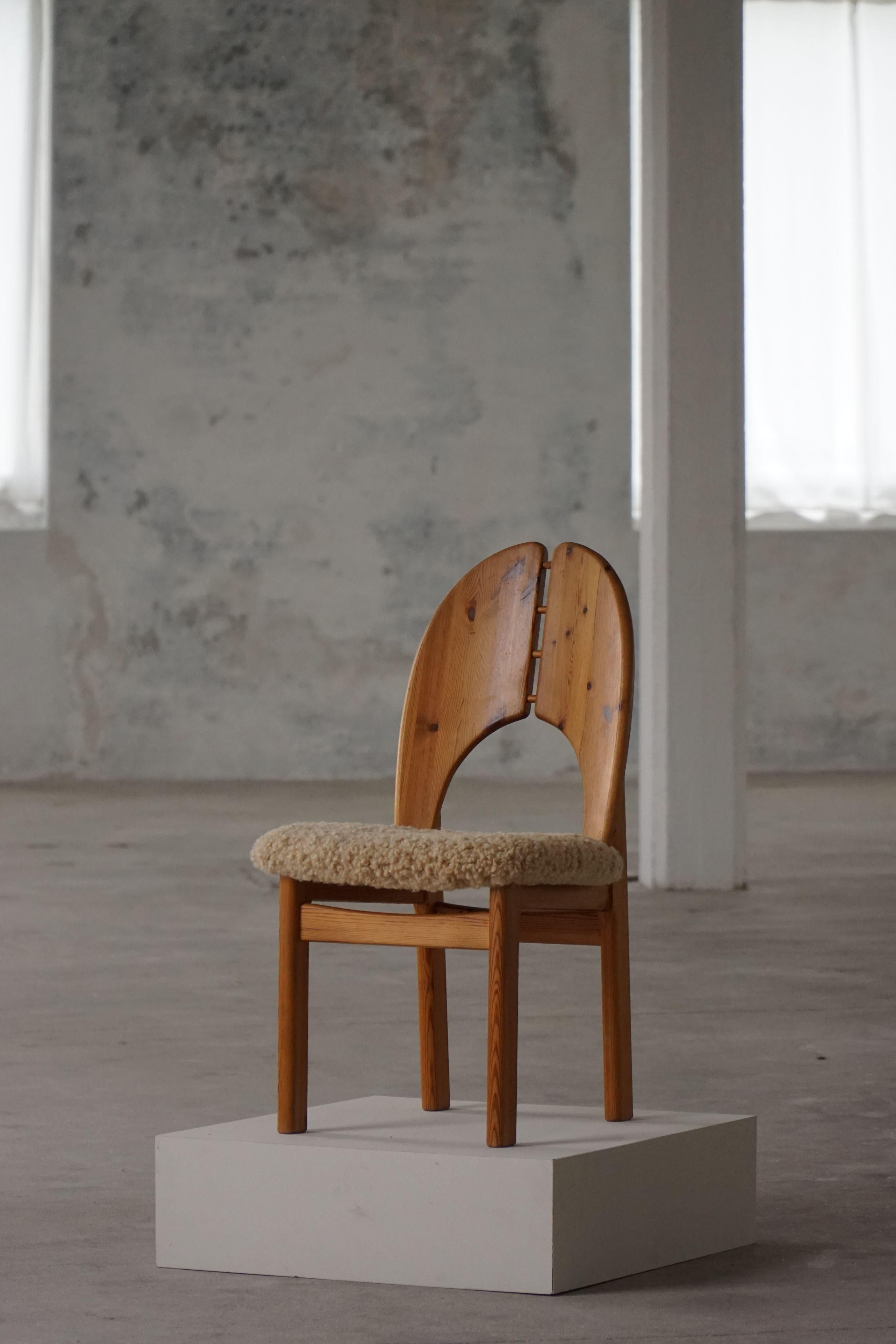 A neat set of 8 sculptural dining chairs in solid pine, upholstered in a fine quality shearling lambswool, made in the 1970s. These chairs have a really strong impression that pairs well with many types of interior styles. A Modern, Scandinavian,