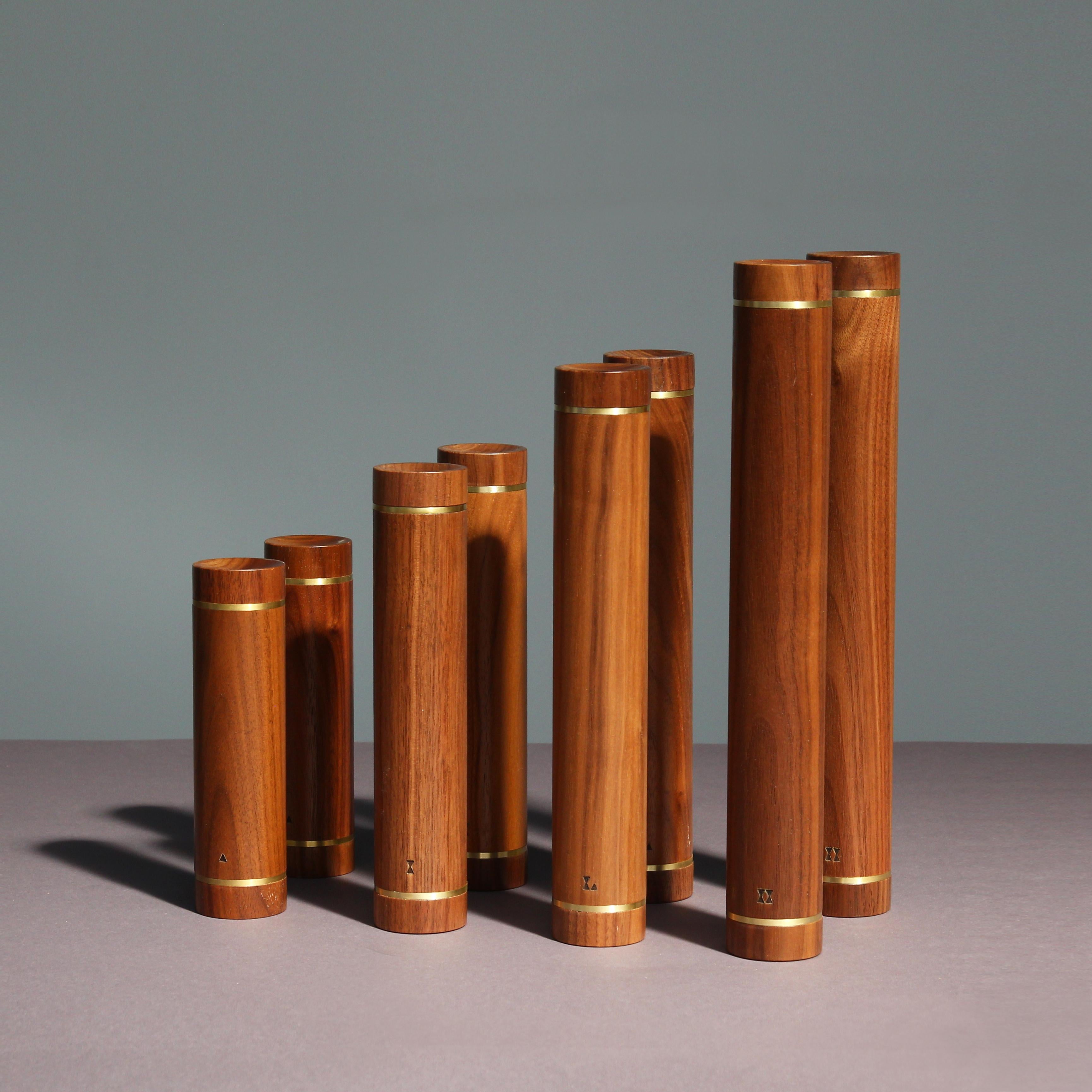 Ein Satz von acht schönen Hanteln aus Walnussholz und einem Metallkern im Inneren. Die Hanteln haben eine minimalistische und elegante Form, die mit Messingringen veredelt ist. Passend zu jeder Einrichtung auf Sideboards, Regalen oder Couchtischen