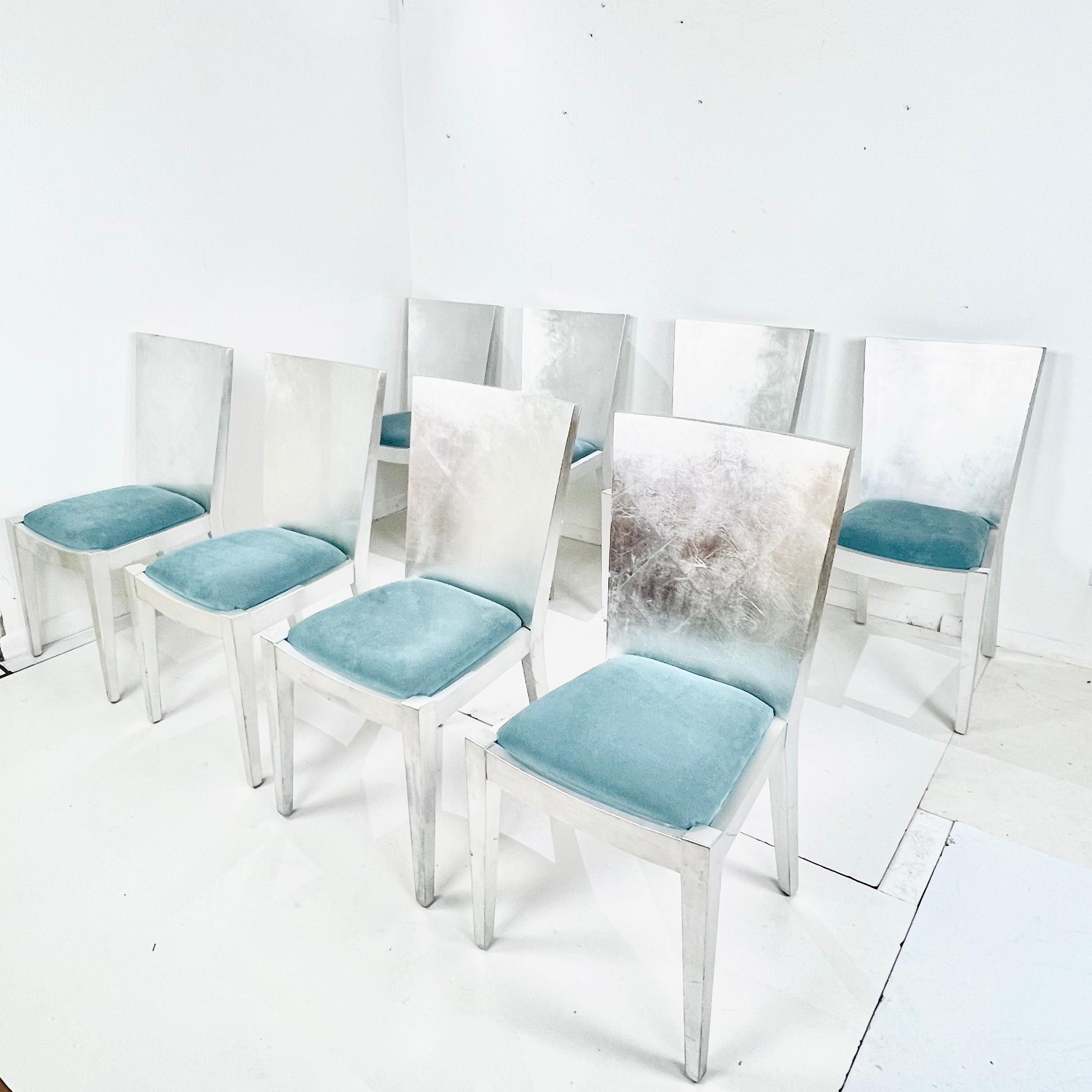 Spectacular set of 8 silver leaf dining chairs in the style of Karl Springer's iconic JMF chairs. Excellent joinery and craftsmanship, with a lightly distressed patina on the silver leaf finish. Recently upholstered in a light teal blue velvet and