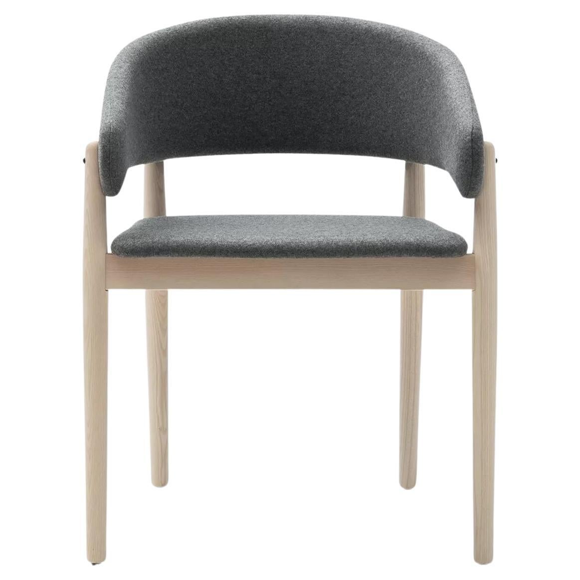 Eine große, gewölbte, umlaufende ergonomische Rückenlehne ist das Element, aus dem sich dieses Design visuell zusammensetzt. Diese wird an vier Punkten von stumpfen Holzstäben gestützt, die auf den Boden abgesenkt werden und zu Beinen werden.
Ein