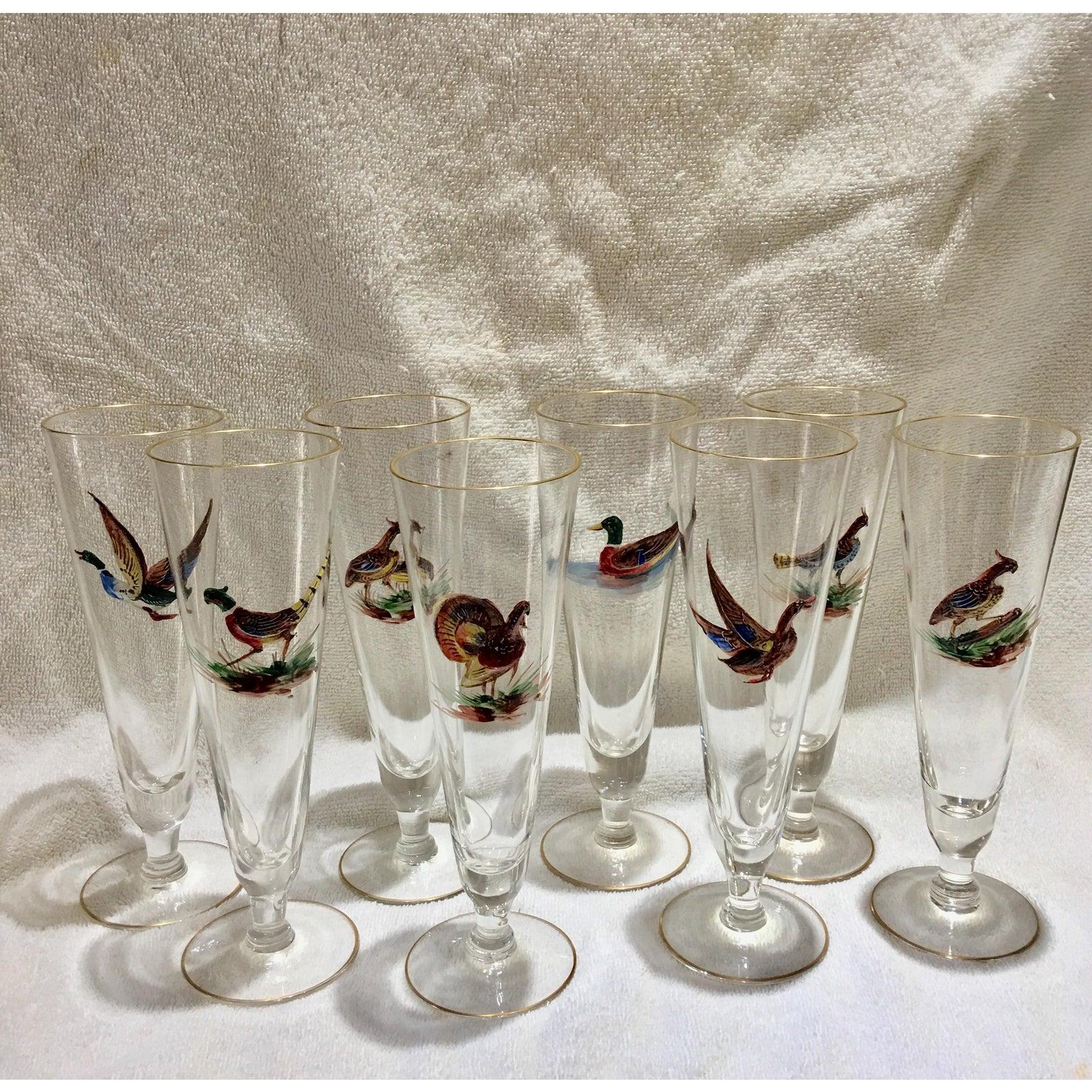 Rare set of 8 European pilsner or champagne flutes with enameled birds with gold rims on the top and bottom. The enameling extends out from the glass. These fabulous glasses date from 1920-1930. These glasses have been packed away and were never
