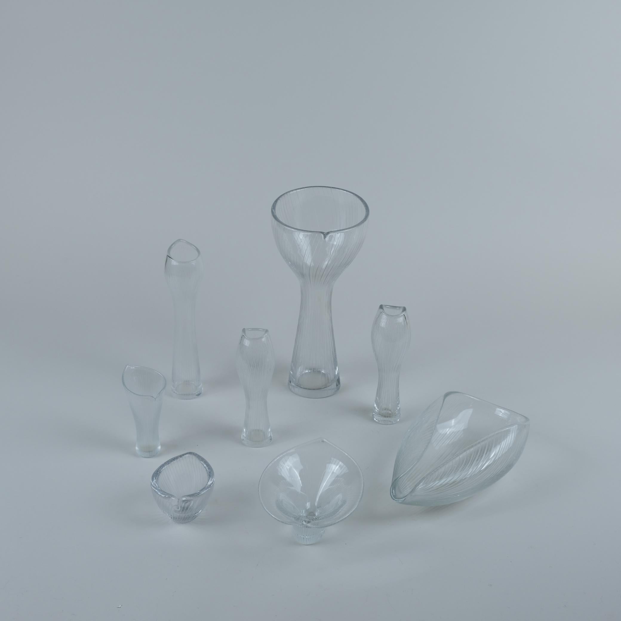 A set of eight Tapio Wirkkala Tulip art objects / vases for Iittala. The set is of different pieces from the line engraved series that is highly inspired by nature including flowers, seashell, mushrooms, animals, etc. The vases vary in size from