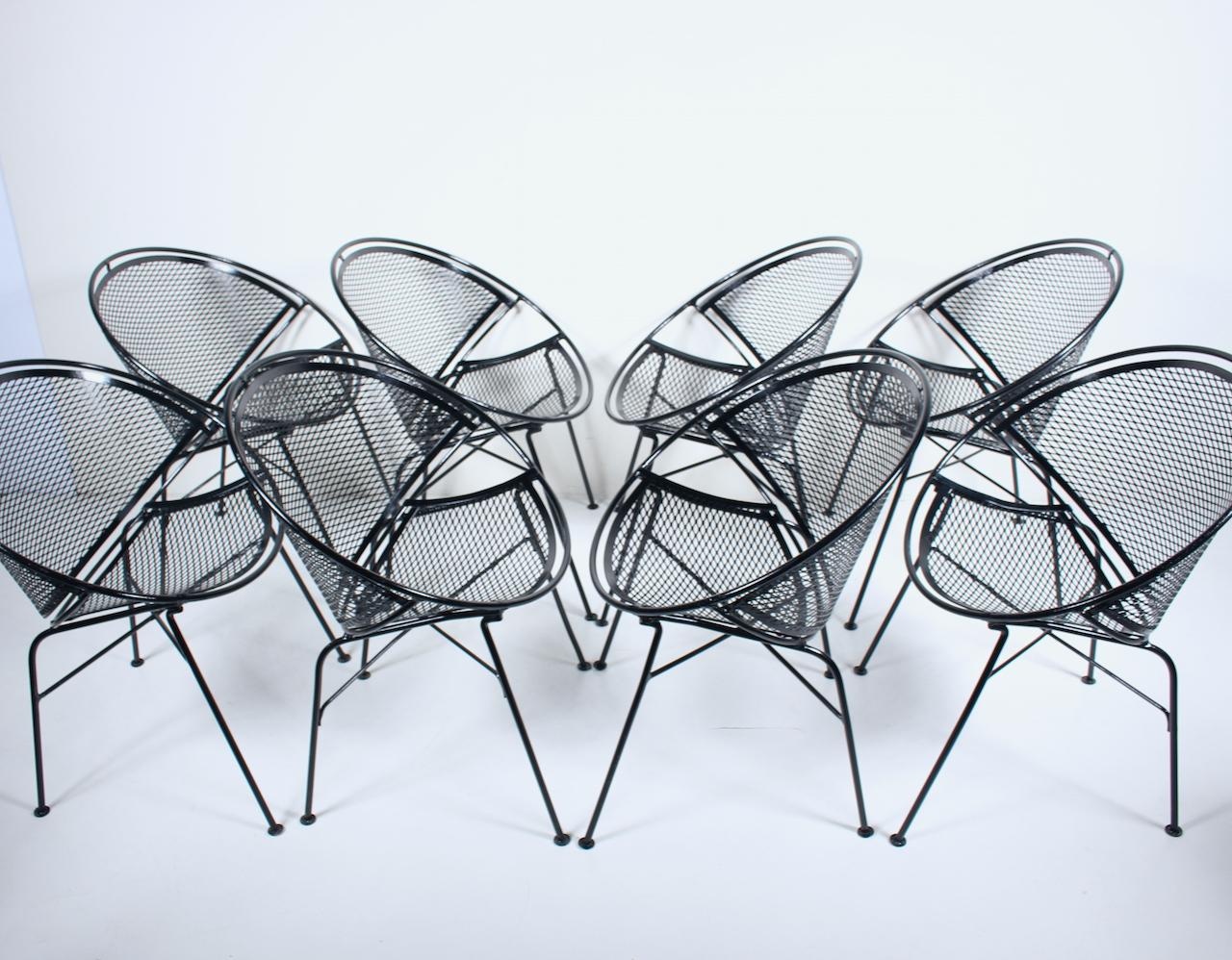 Original Maurizio Tempestini for Salterini set of eight radar dining armchairs. Featuring sculpted sturdy hoop frameworks in black enameled wrought iron, curved ergonomic full backs, with comfortable wire mesh backs and seats detailed with glide
