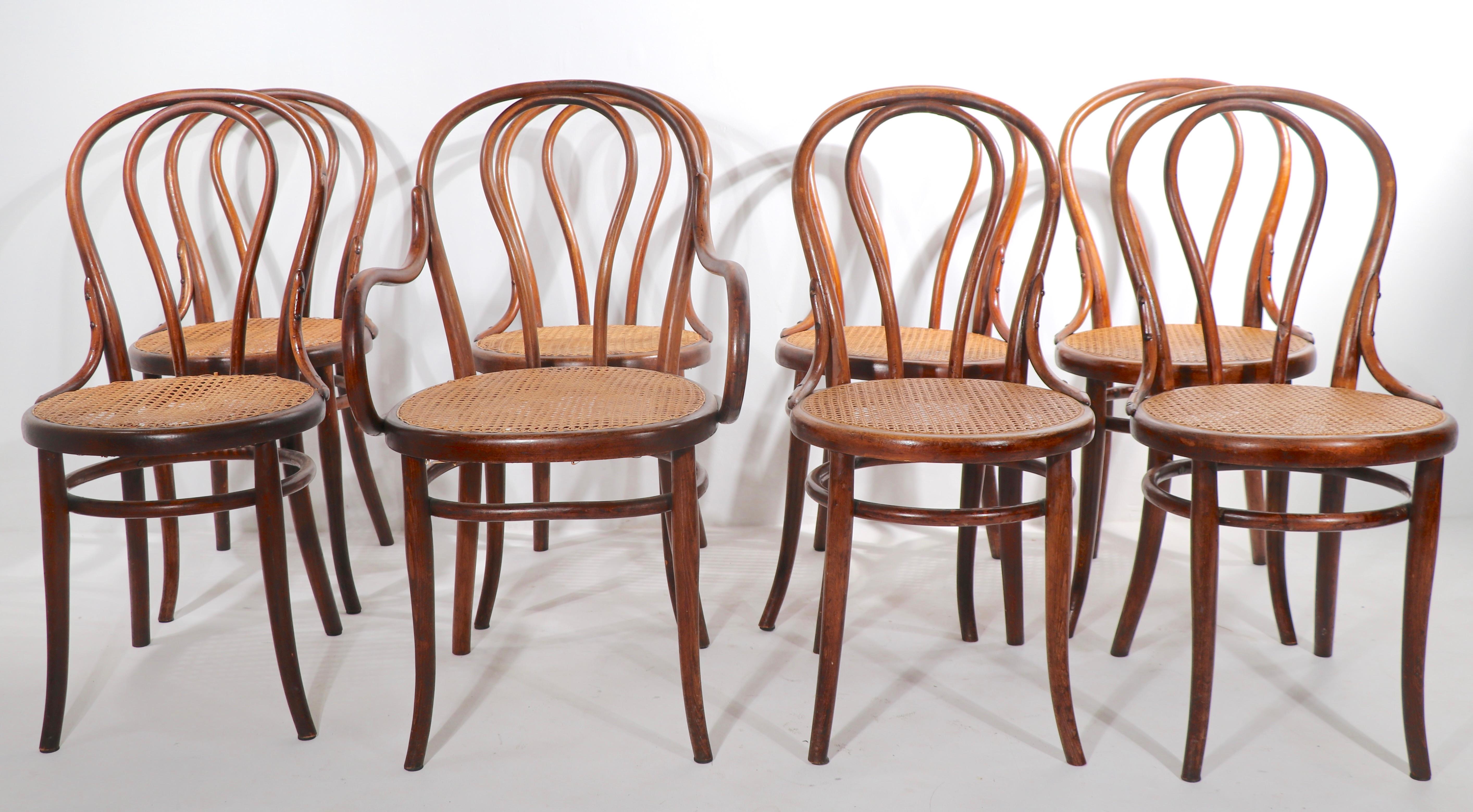 Rare complete set of 8 matching bentwood chairs by Thonet. This set includes 7 armless, or side, chairs and 1 arm, or Captains' chair. All are in very good, solid, sturdy and ready to use condition. 
 Dimensions of Side Chairs:
 Total H 35 x Seat