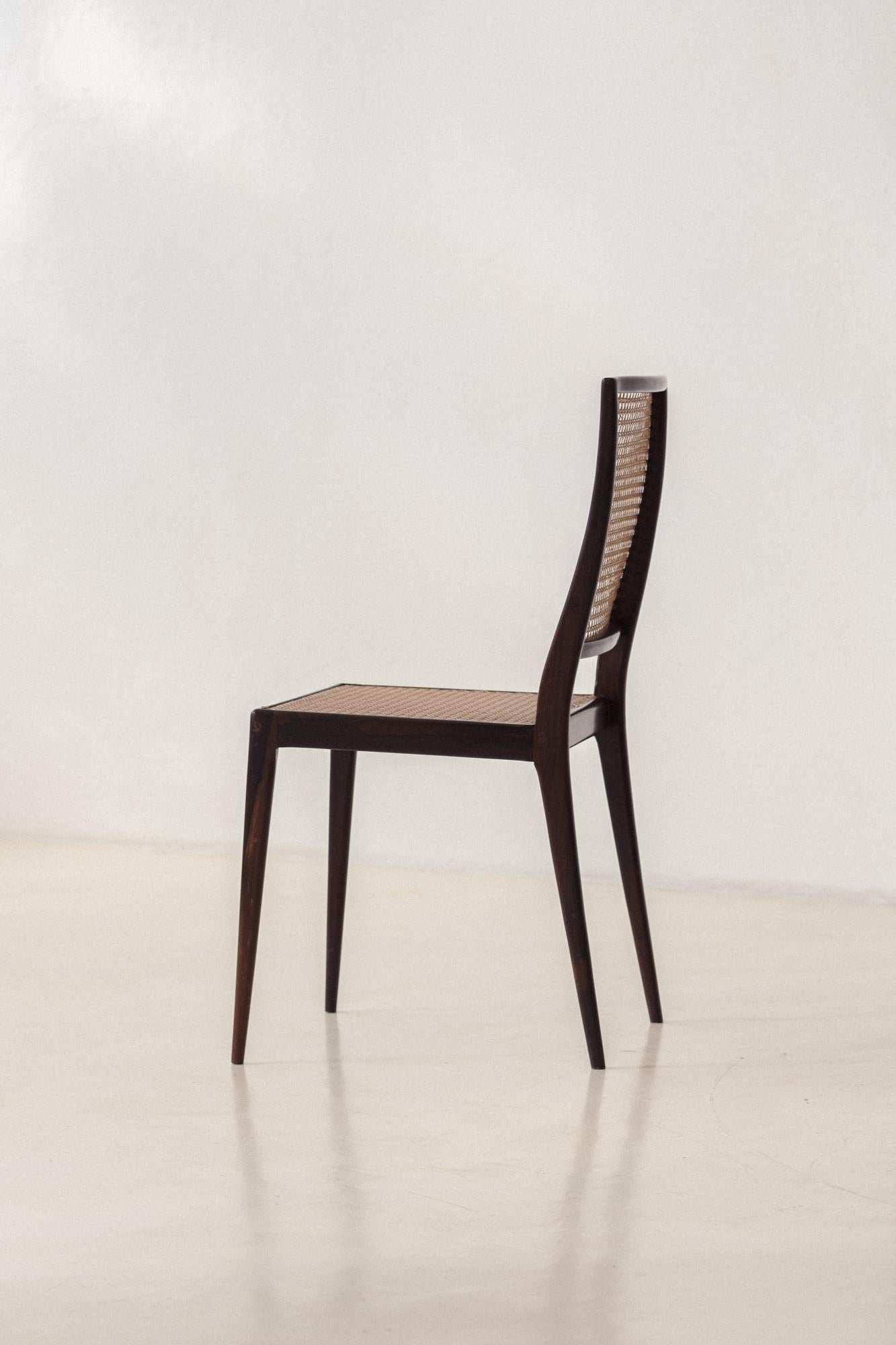 This incredible set of eight MT 552 chairs designed by Geraldo de Barros (1923-1998) and manufactured by Unilabor has a frame in solid rosewood with cane backrests and seats. Because it is a less dense material, the delicate cane weave for furniture