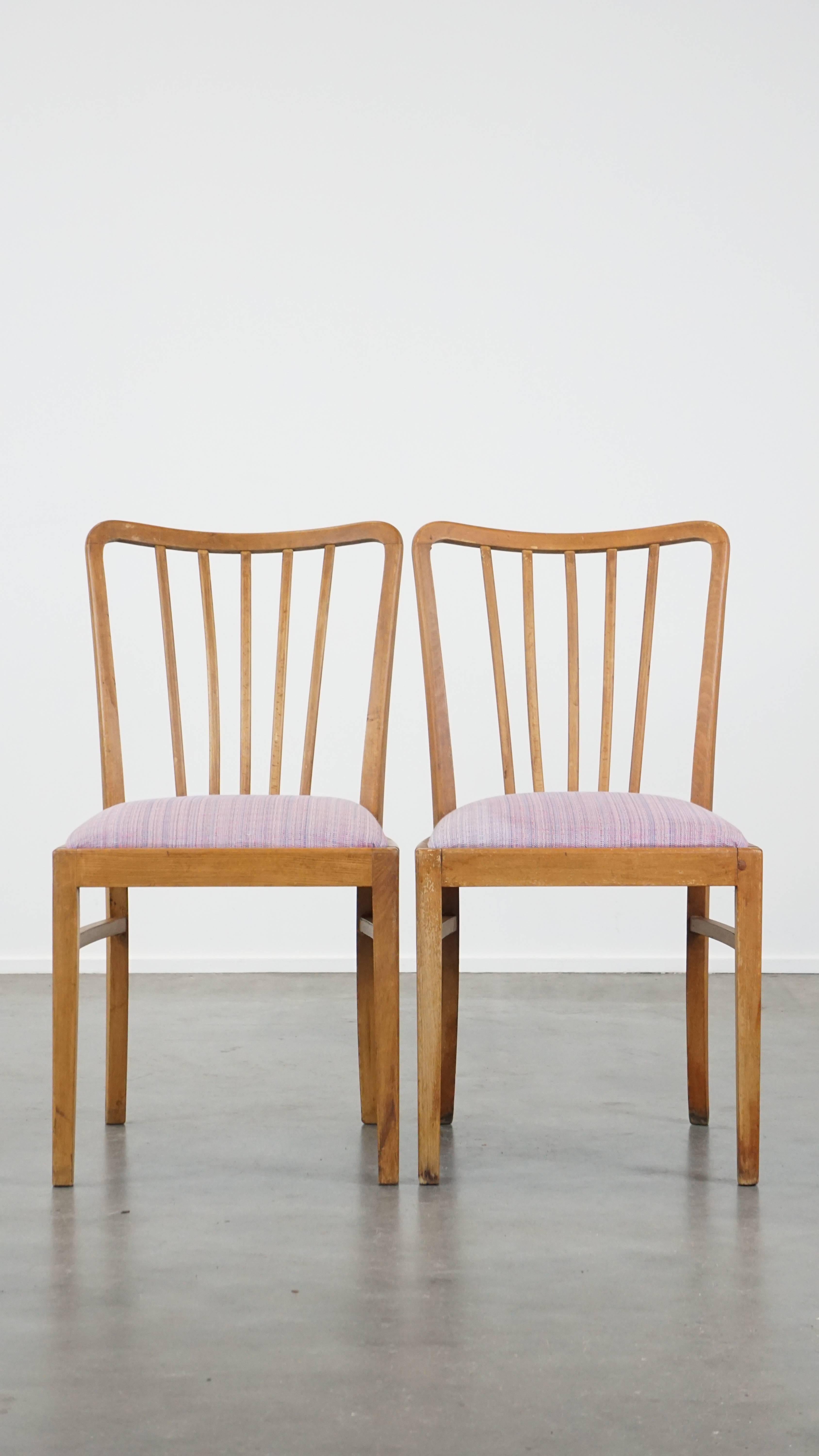 Questo set di 8 sedie da pranzo vintage degli anni '70 emana tranquillità, fascino e intimità. Presentano una struttura in legno con schienale a fuso e sedute in tessuto. A causa degli anni di utilizzo, hanno acquisito normali segni di usura e