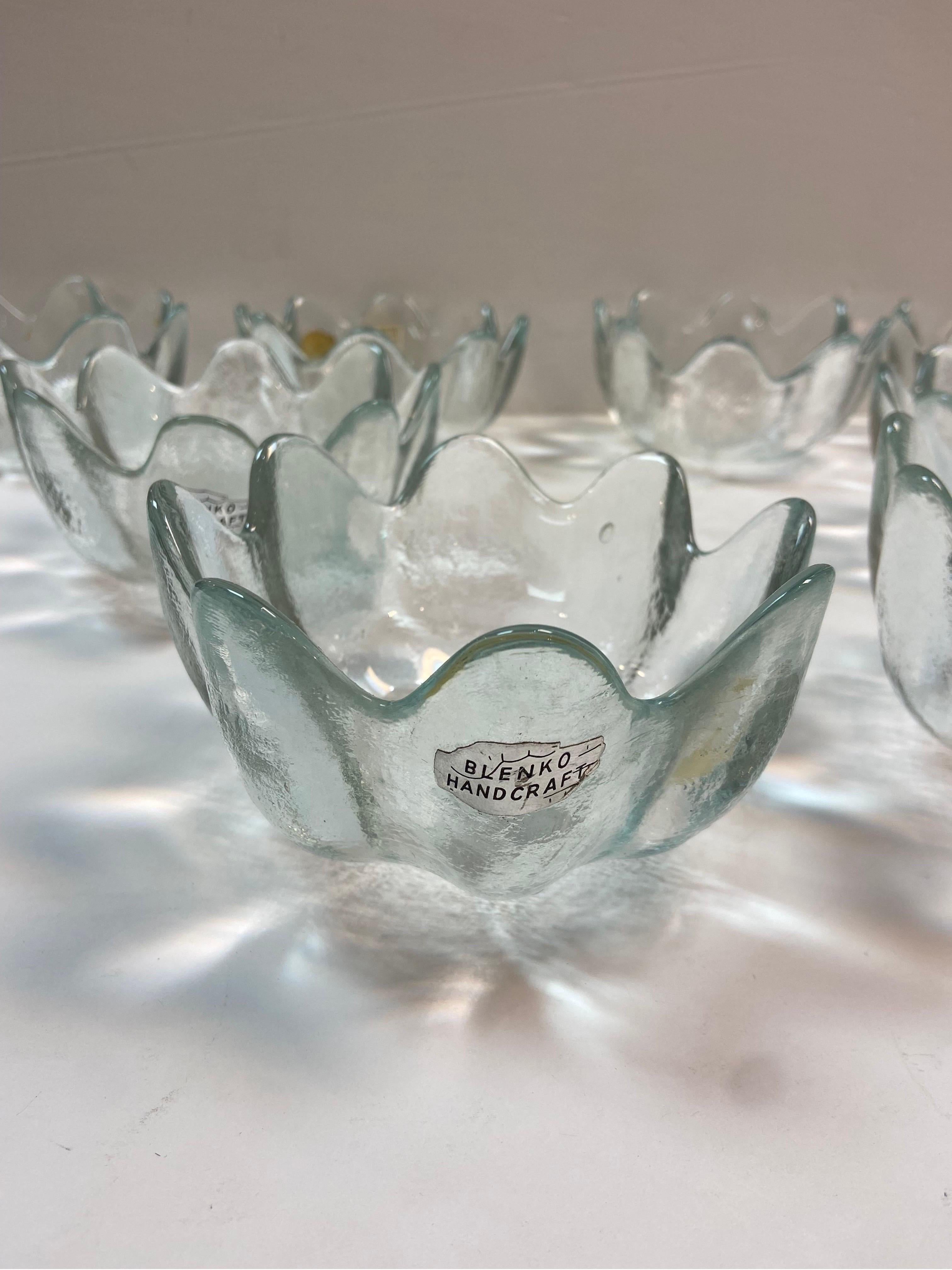 A vintage set of eight Blenko Petal or Lotus shaped bowls in crystal clear. Wayne Husted is the designer of this bowl. He was a designer for Blenko from about 1952 to 1963. Most retain their original Blenko labels. From the Blenko website, 