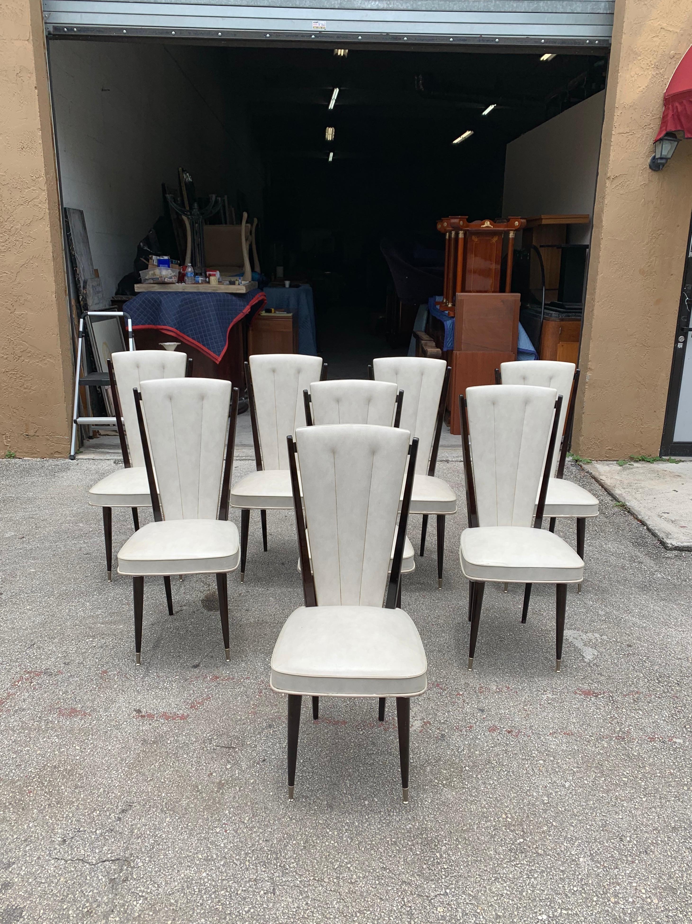 Classic set of six French Art Deco dining chairs solid mahogany, the two front feet are capped with brass. The chair frames are in excellent condition. The Reupholstery is vinyl recommended to be change for all 8 dining chairs but the vinyl look