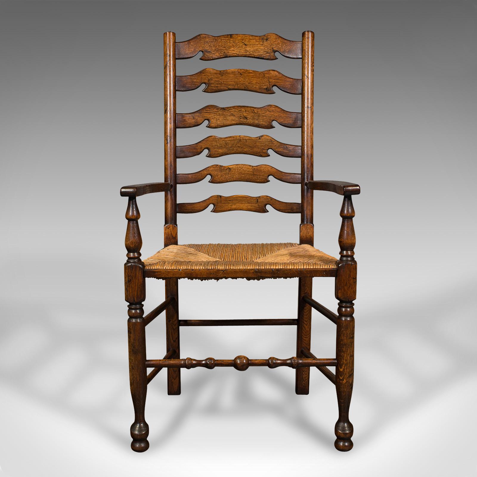 This is a set of 8 vintage Lancashire wavy line ladder back chairs. An English, oak and woven rush dining suite with Georgian revival taste, dating to the late 20th century, circa 1980.

Large dining suite of two carvers and six chairs of superb