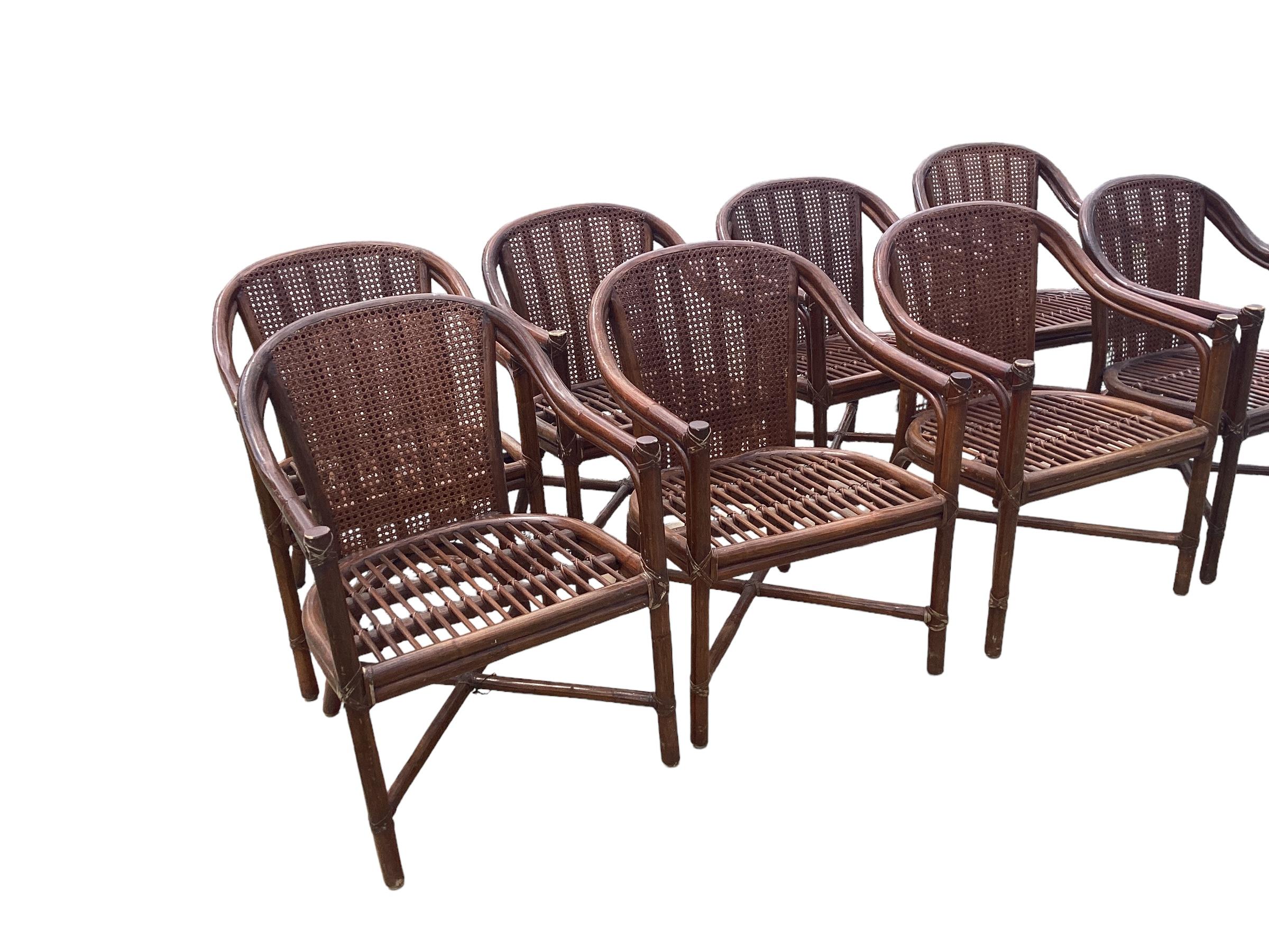 A set of eight McGuire Rattan Dining. Each with a barrel shaped caned back. The chairs all need new cushions and upholstery. There is wear and finish  loss on parts of the chairs. All retain the McGuire metal plaque. 
Please reach out for