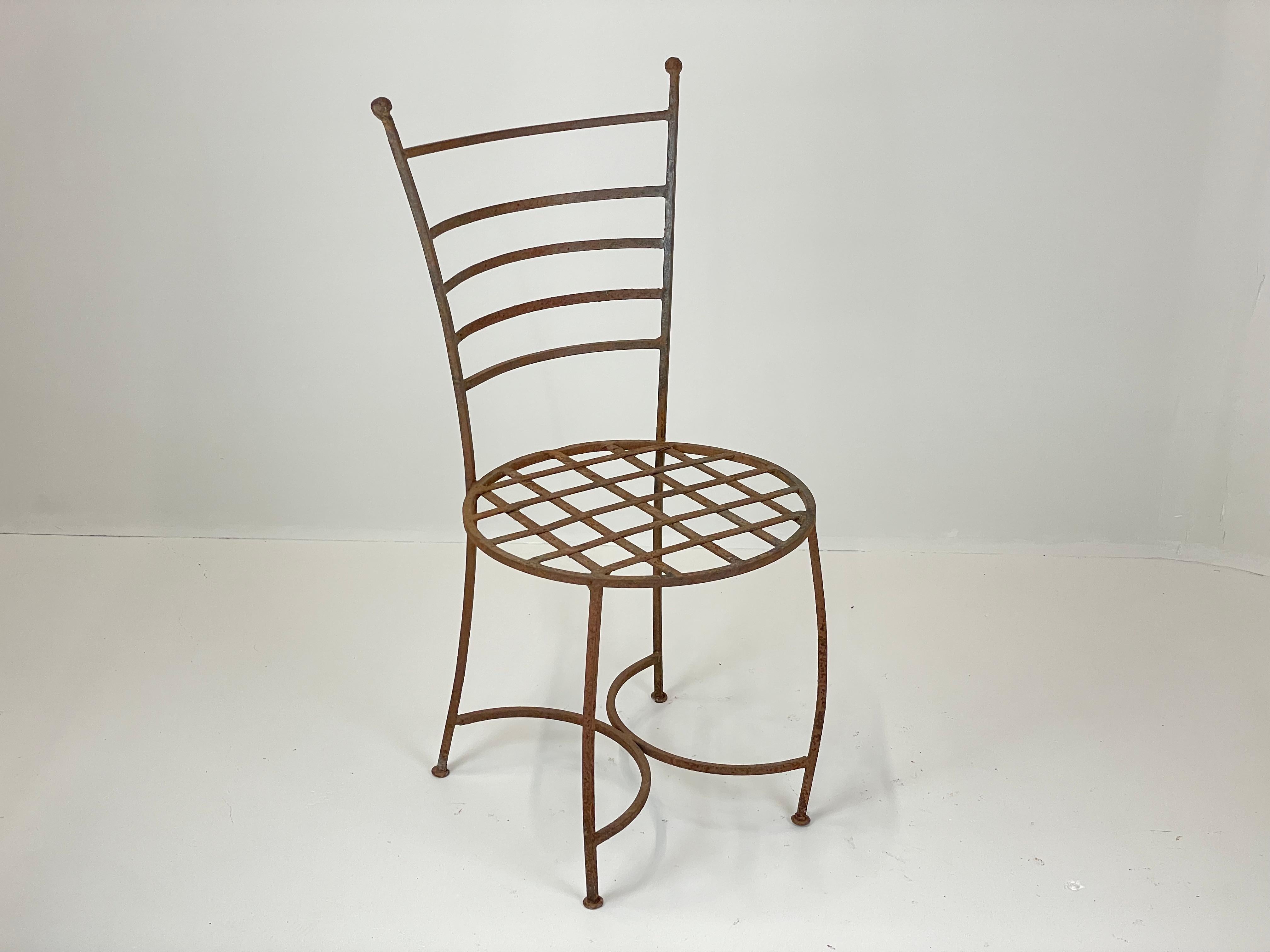 A wonderful Spanish set of eight Andalusian wrought iron courtyard or terrace garden chairs, with ladder backs and ball finials above lattice-iron seats. The splayed legs are joined by curving stretchers, giving strength and sculptural form.

These