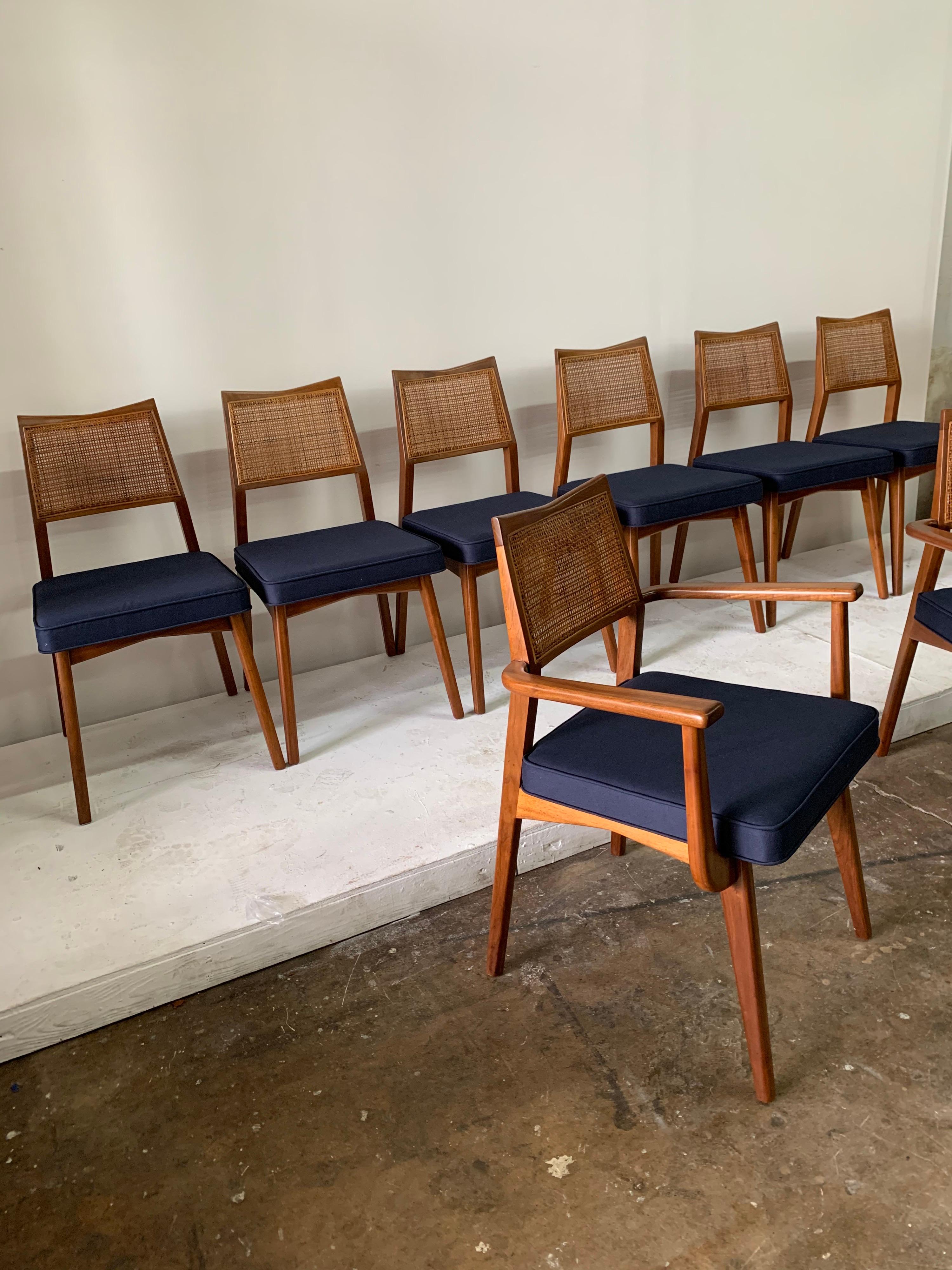 Eight vintage walnut, original cane and navy blue cotton upholstered seats. Two armchairs for host and hostess, 6 armless guest chairs. Possible by Jens Risom; These compliment beautifully Nakashima or Prouve furniture.

Note: dimensions of armed