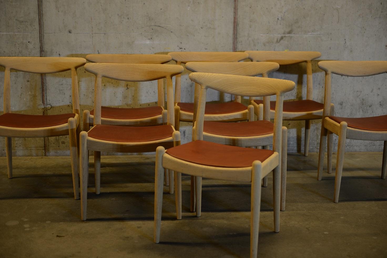 Set of 8 dining chairs in soaped oakwood with new leather seats. Newly re-upholstered with the finest cognac coloured leather from the Swedish Tärnsjö tannery. The chairs were designed by Danish designer Hans J. Wegner in the early 1950s. Produced