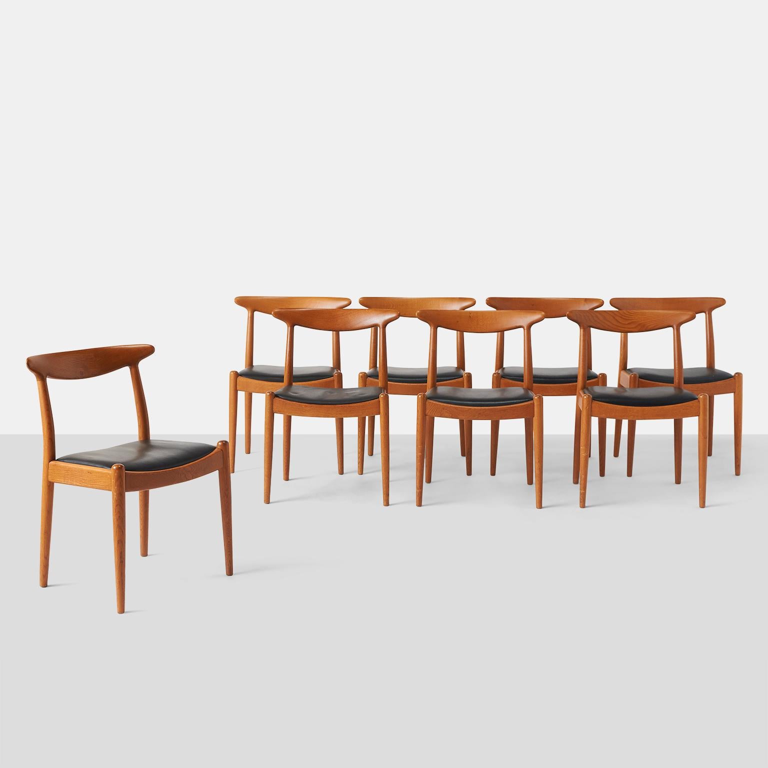 A set of eight W2 oak dining chairs featuring an inset black upholstered seat and tapered legs.

Stamped C M Madsens, made in Denmark, Hans J Wegner.