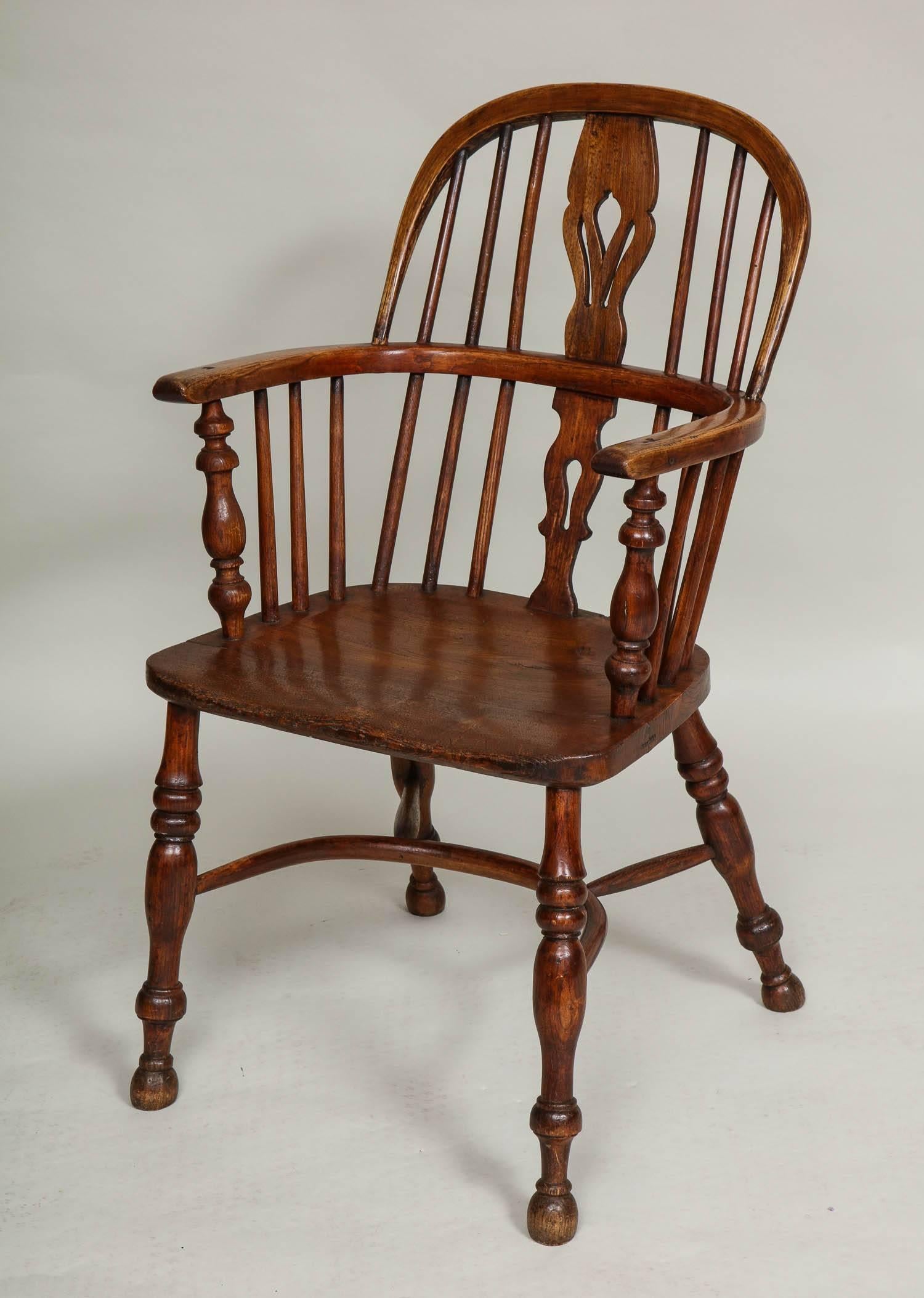 Good assembled set of eight English ash and elm windsor hoop back armchairs having tulip pierced fruitwood backsplats, bent hoop backs and continuous arms, each saddled seat fashioned from a single elm plank, standing on boldly turned legs and