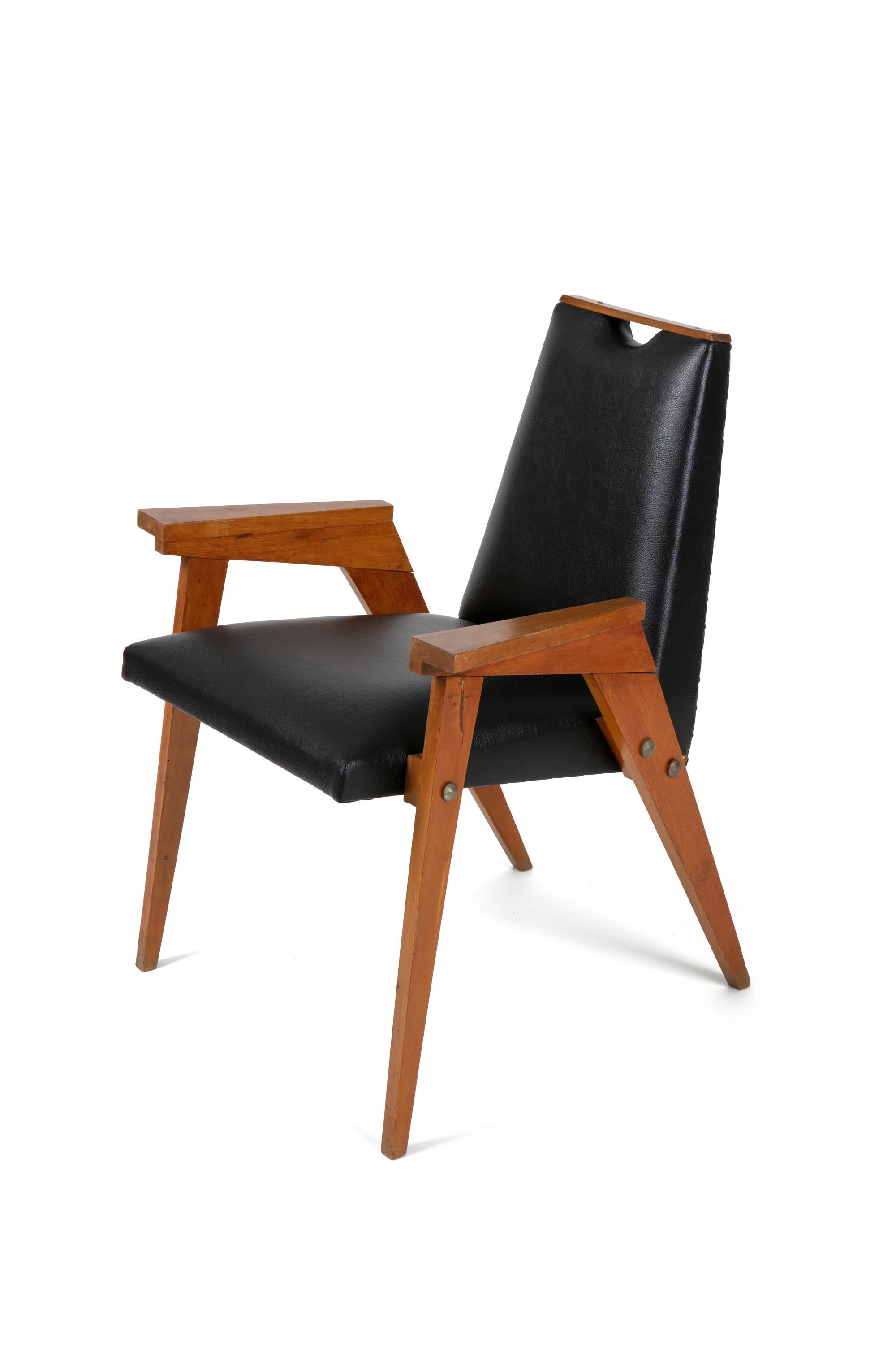 A set of distinctive dining chairs with arms. The wood detail on the top of the back adds to the architectural nature of the chairs and also is convenient for pulling the chair back from the table. One of the eight chairs is slightly lower and has