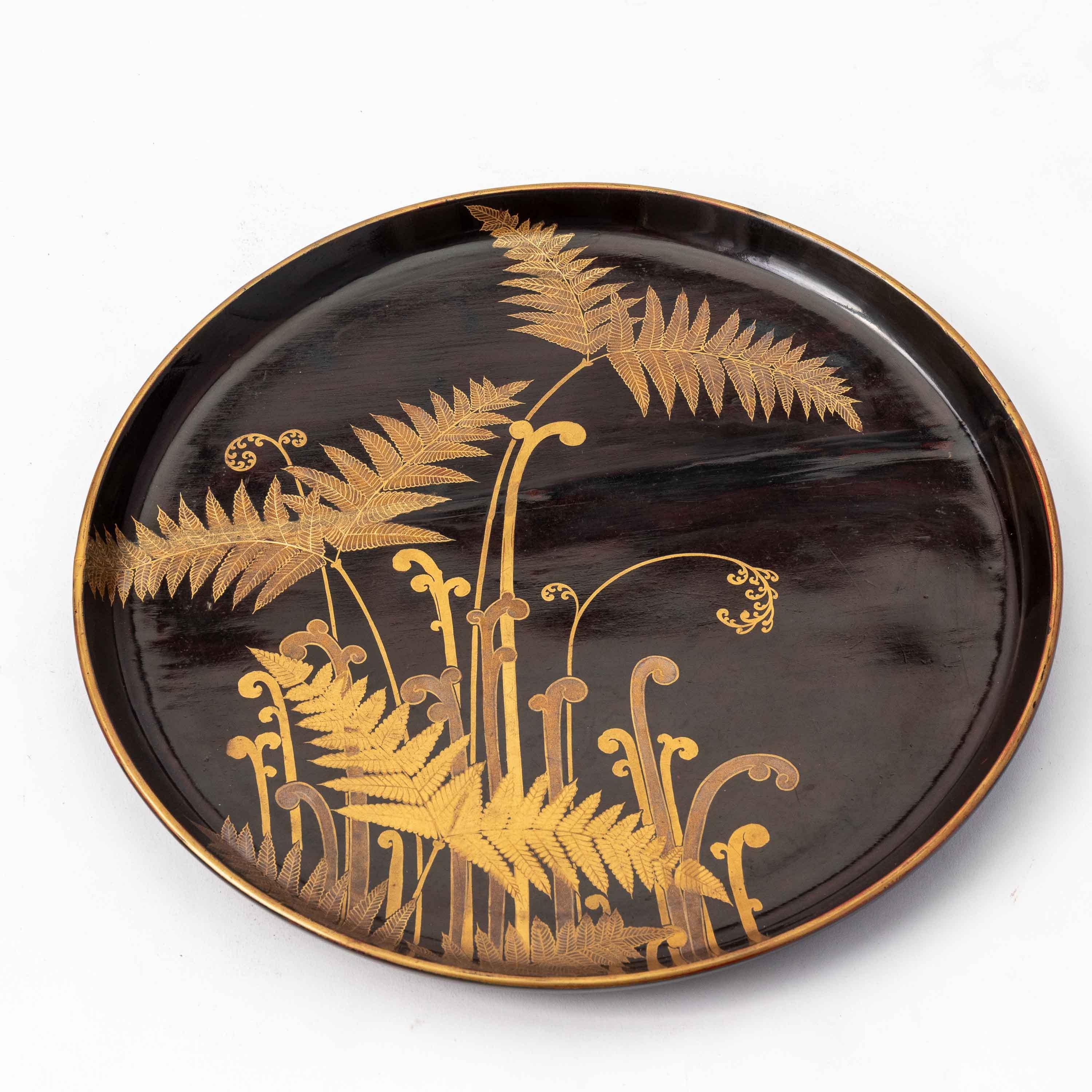 A set of nine circular black lacquer trays each with an individual botanical design of foliage or flowers in delicately wrought gold maki-e. From the Edo period, 18th century. Each design is beautiful and stands alone, however when displayed