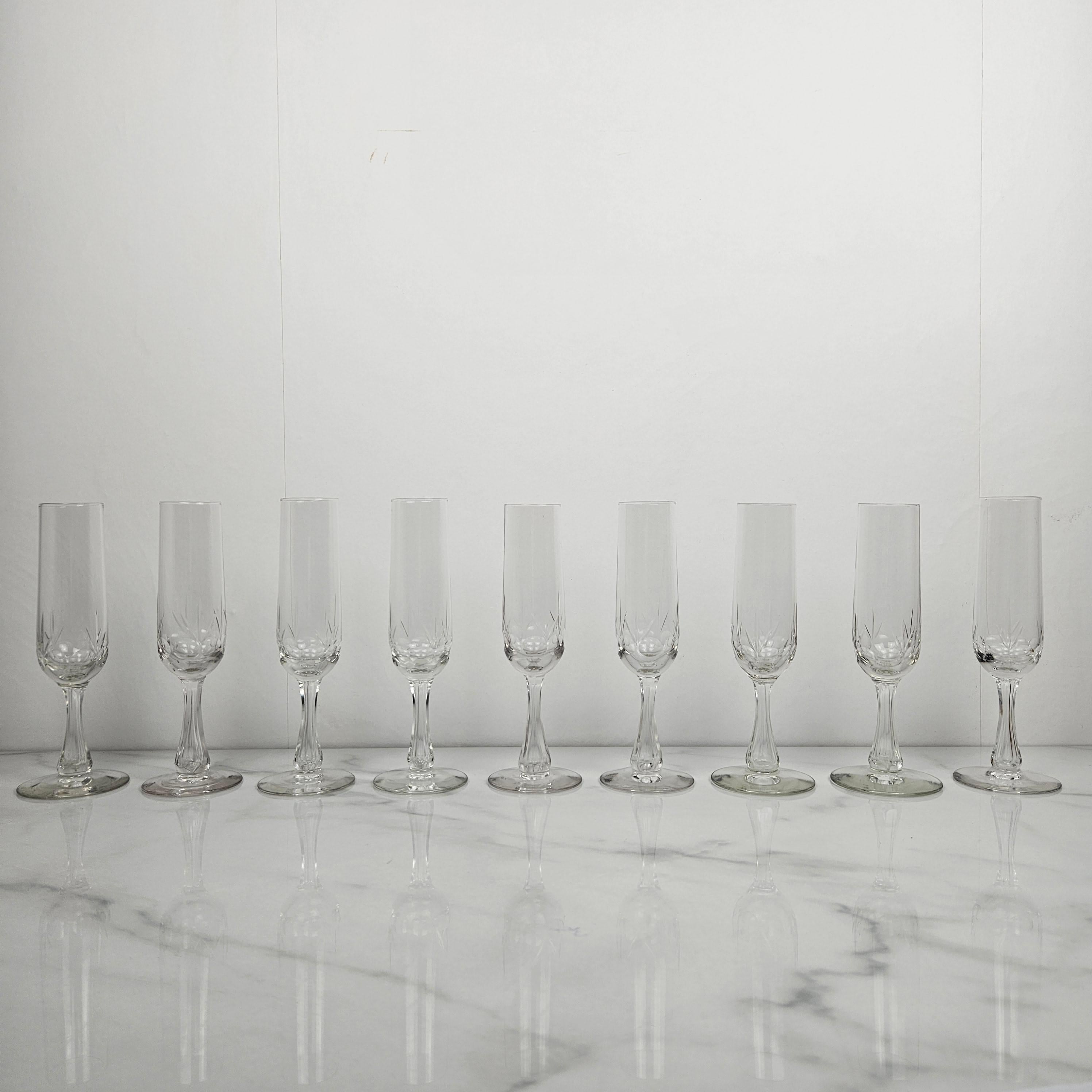 Elegant set of nine French champagne flutes dating from around 1900. 
Each glass is beautifully cut with fine decorative motifs on the bowl and a faceted, cut base — a refined example of Belle Époque glassmaking.

The delicate proportions and crisp