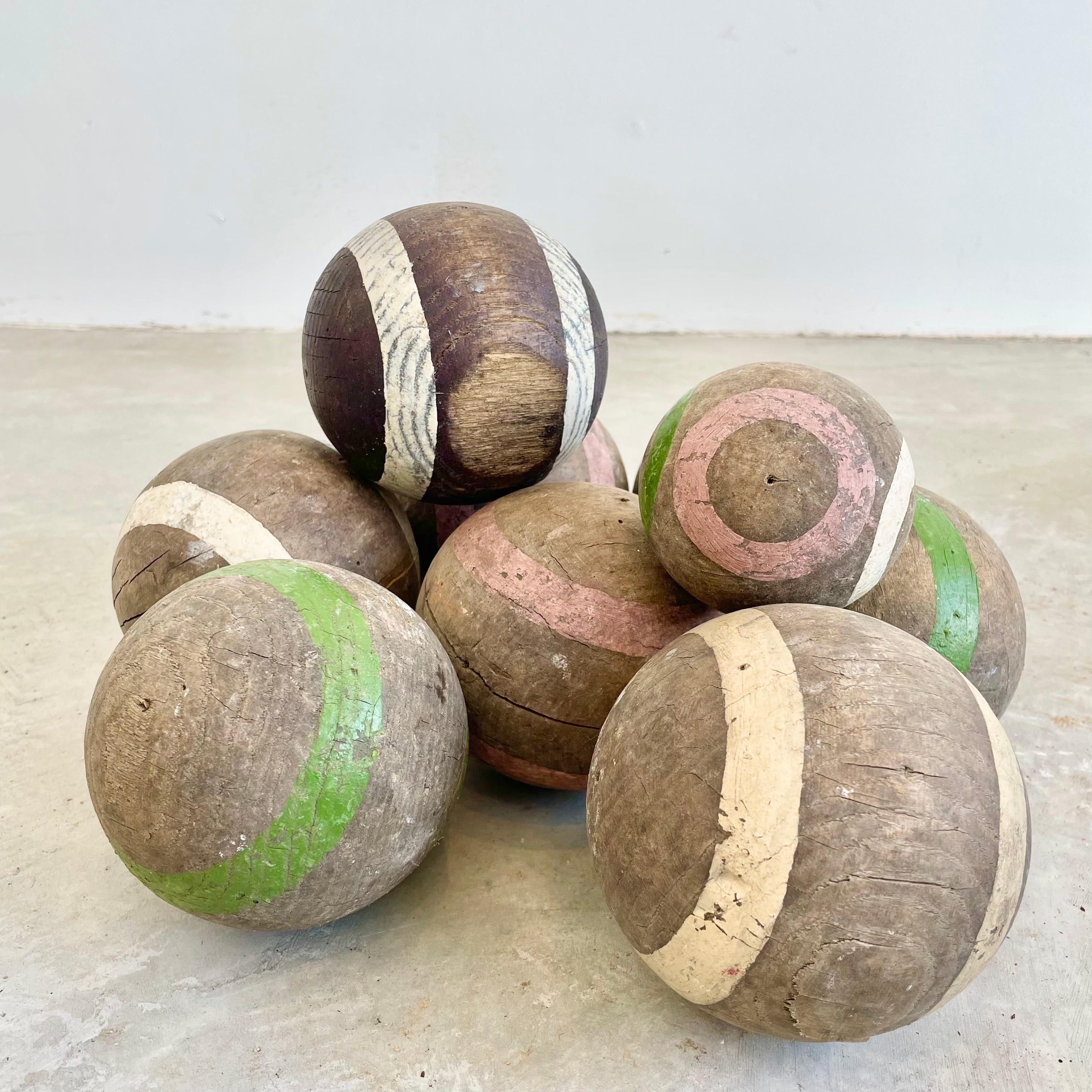 Hand made wooden bocce balls with hand painted green, white and pink rings. Various patinas and colors give the set amazing and depth. Each ball is made of a dense solid wood. Would go beautifully in a bowl as a centerpiece on a coffee table or