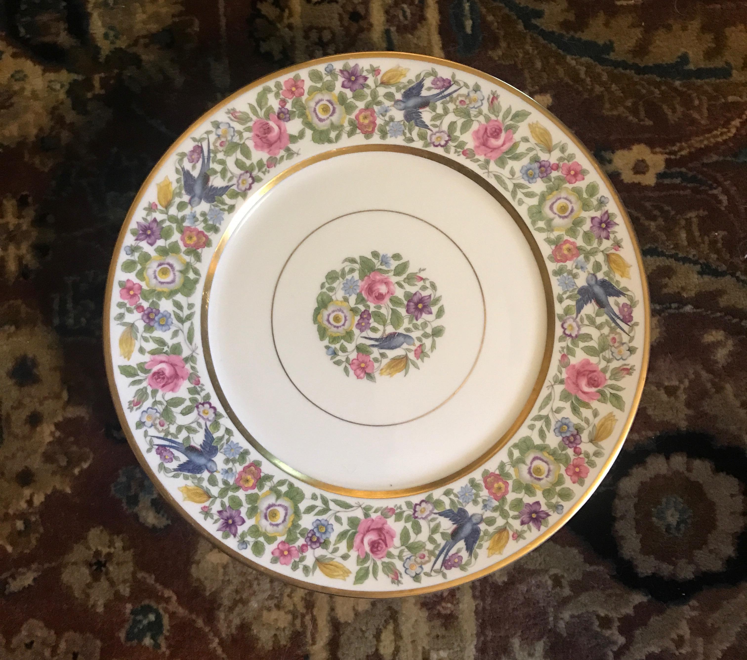 A set of nine floral service plates 10.25 inches in diameter, with gilt banding. The broad floral ban with birds and gold bands with a central floral medallion. The backstamp is from 1939.