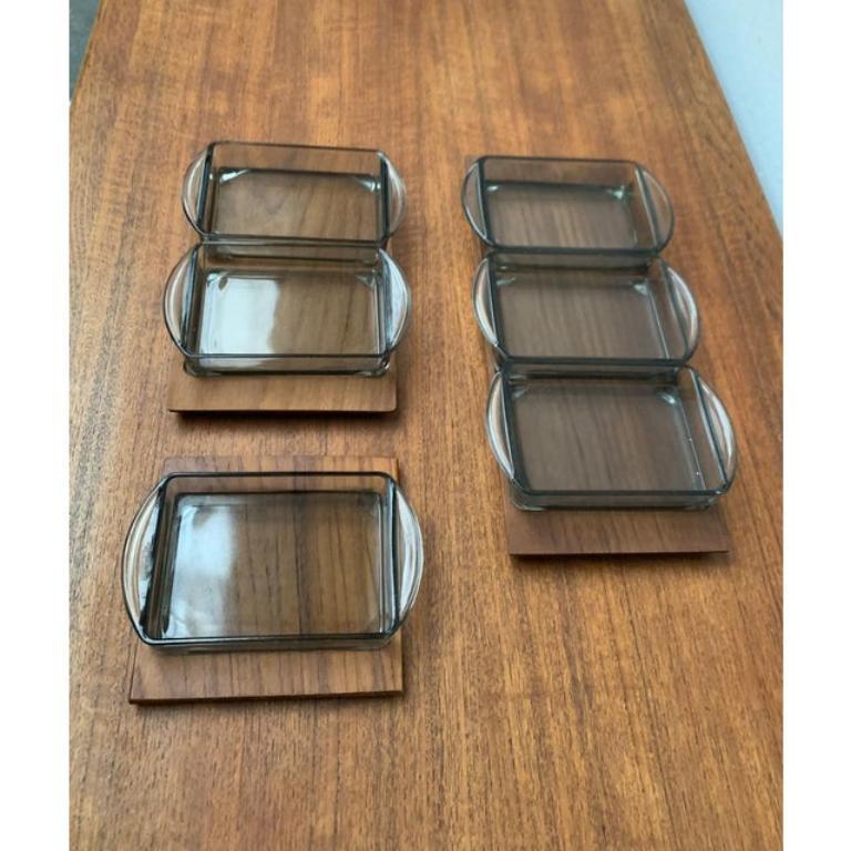 Dänisches Teakholz-Tablett aus der Jahrhundertmitte mit Cabaret-Glas-Tabletts von Holmegaard, 1960er Jahre, 9er-Set, in sehr gutem Zustand. Entworfen 1960 bis 1969

Zusätzliche Informationen:
MATERIALIEN: Glas, Teakholz
Farbe: Braun
Stile: Moderne