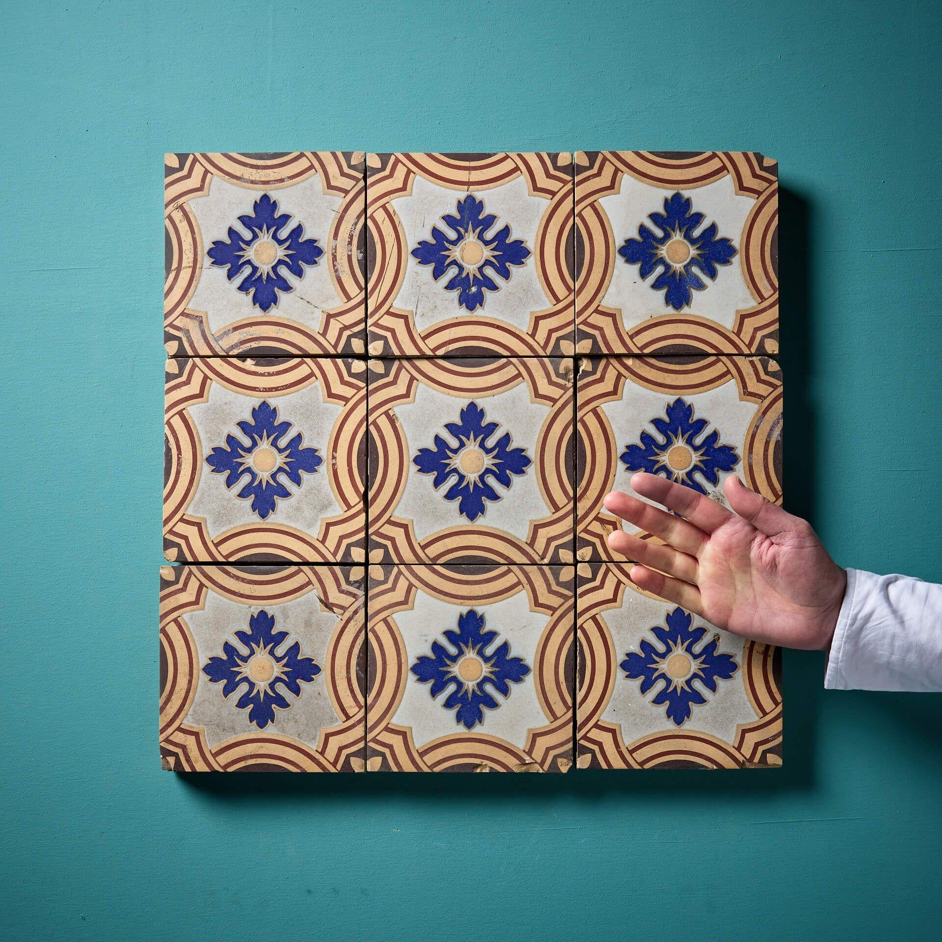 A stunning set of nine 6-inch encaustic patterned tiles by Minton & Co, Stoke-on Trent (stamped).

These antique tiles feature a beautiful design of dark blue flowers on a white backdrop, making an attractive feature of a bathroom or kitchen as an