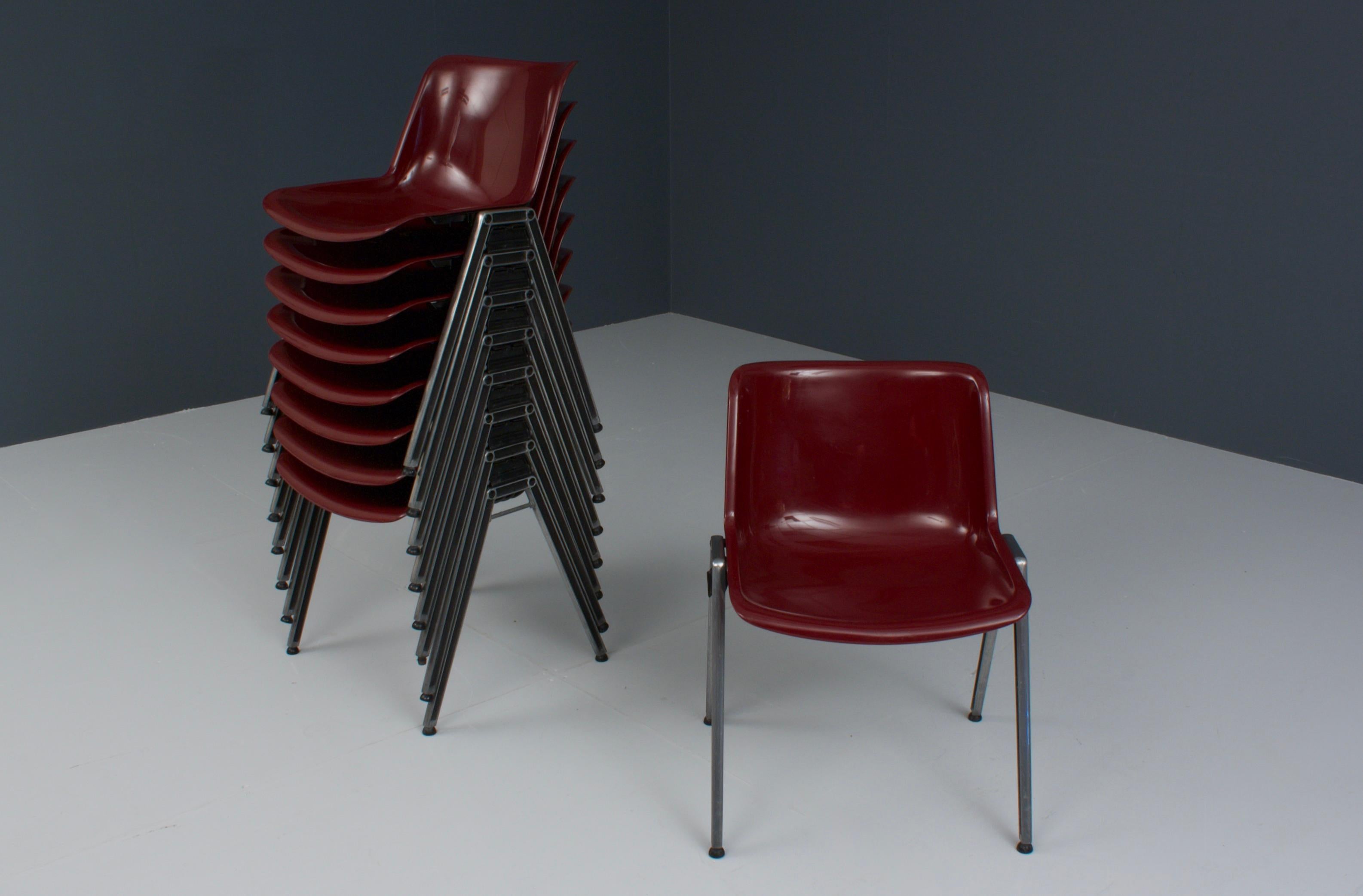 Set of nine wonderful stacking chairs by Osvaldo Borsani for Tecno, Italy. The chairs haven't been produced much in this color, it is a beautiful shiny Bordeaux red quite rare and distinct. The chairs have the usual Borsani metal frame with ABS