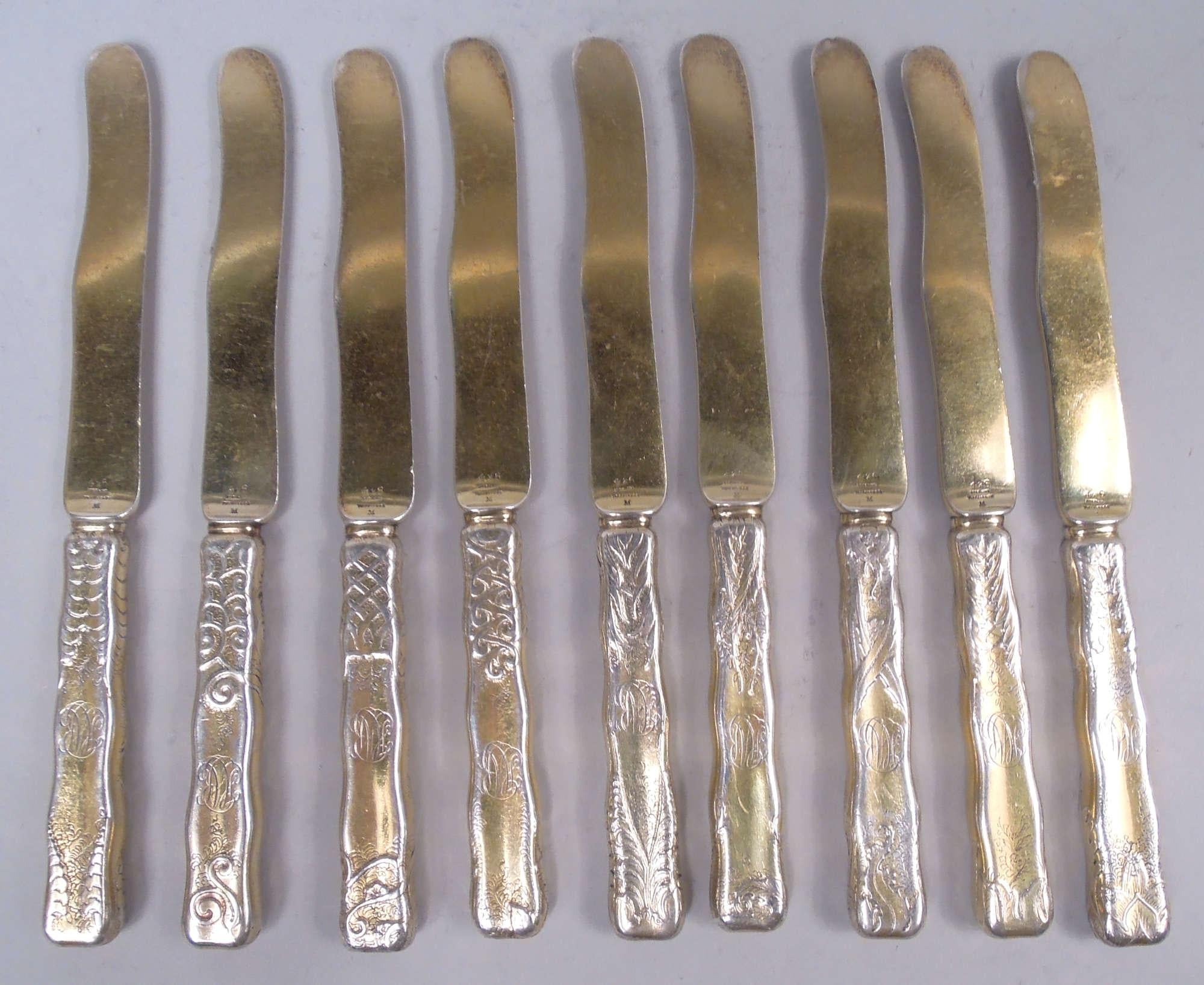 Set di 9 coltelli da dessert in argento dorato Lap Over Edge. Realizzato da Tiffany & Co. a New York. Manici e lame in serpentino con felci e fiori incisi all'acido con volute e pannocchie in disposizione a pell-mell. Ogni coltello è diverso.