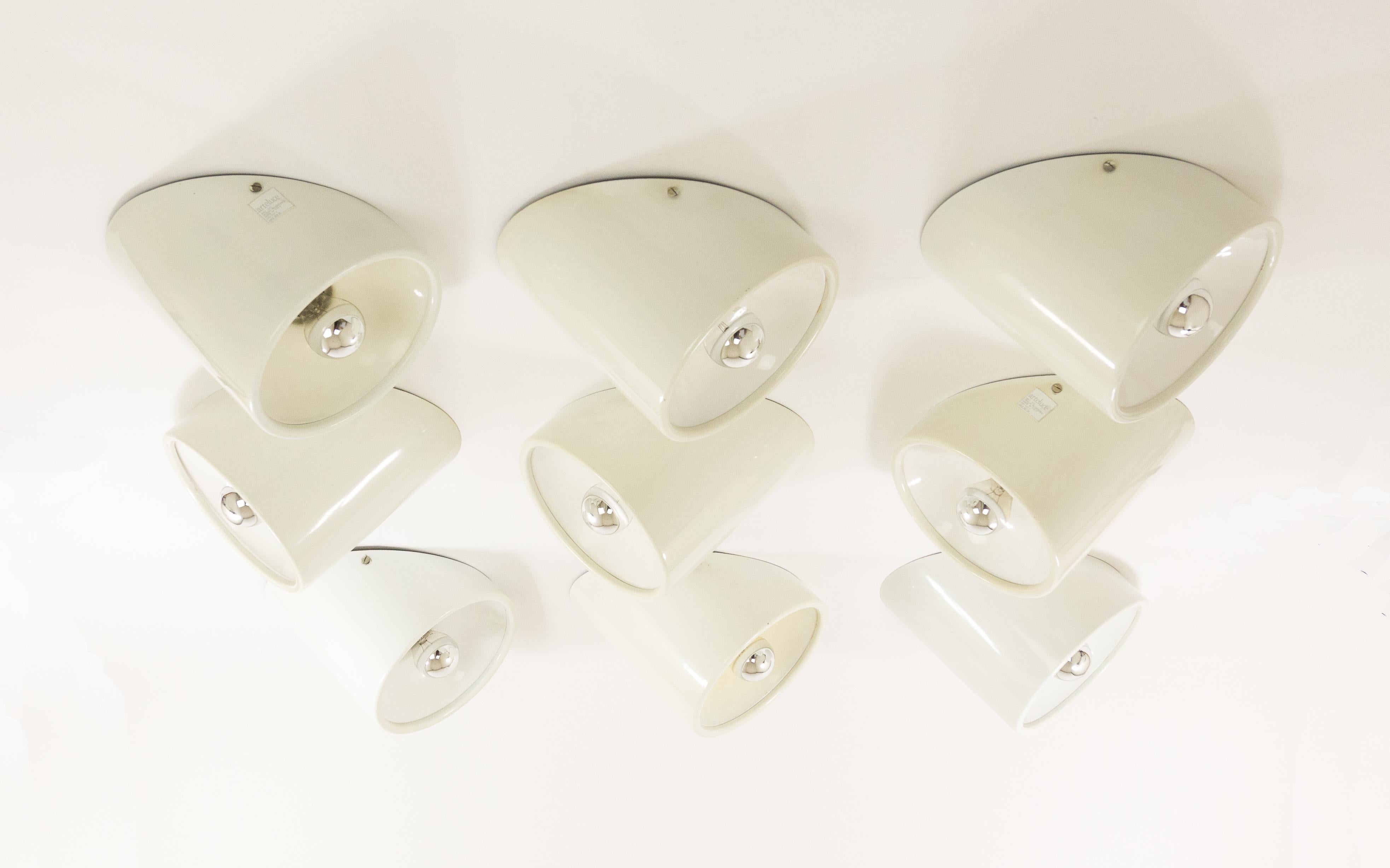 Set of 9 wall or ceiling fixtures, No. 235/b, designed by architect Cini Boeri and manufactured by Arteluce in 1971.

Each lamp consists of two parts: the cylindrical outside and the inside (a reflector). Both parts are (off-)white lacquered. The
