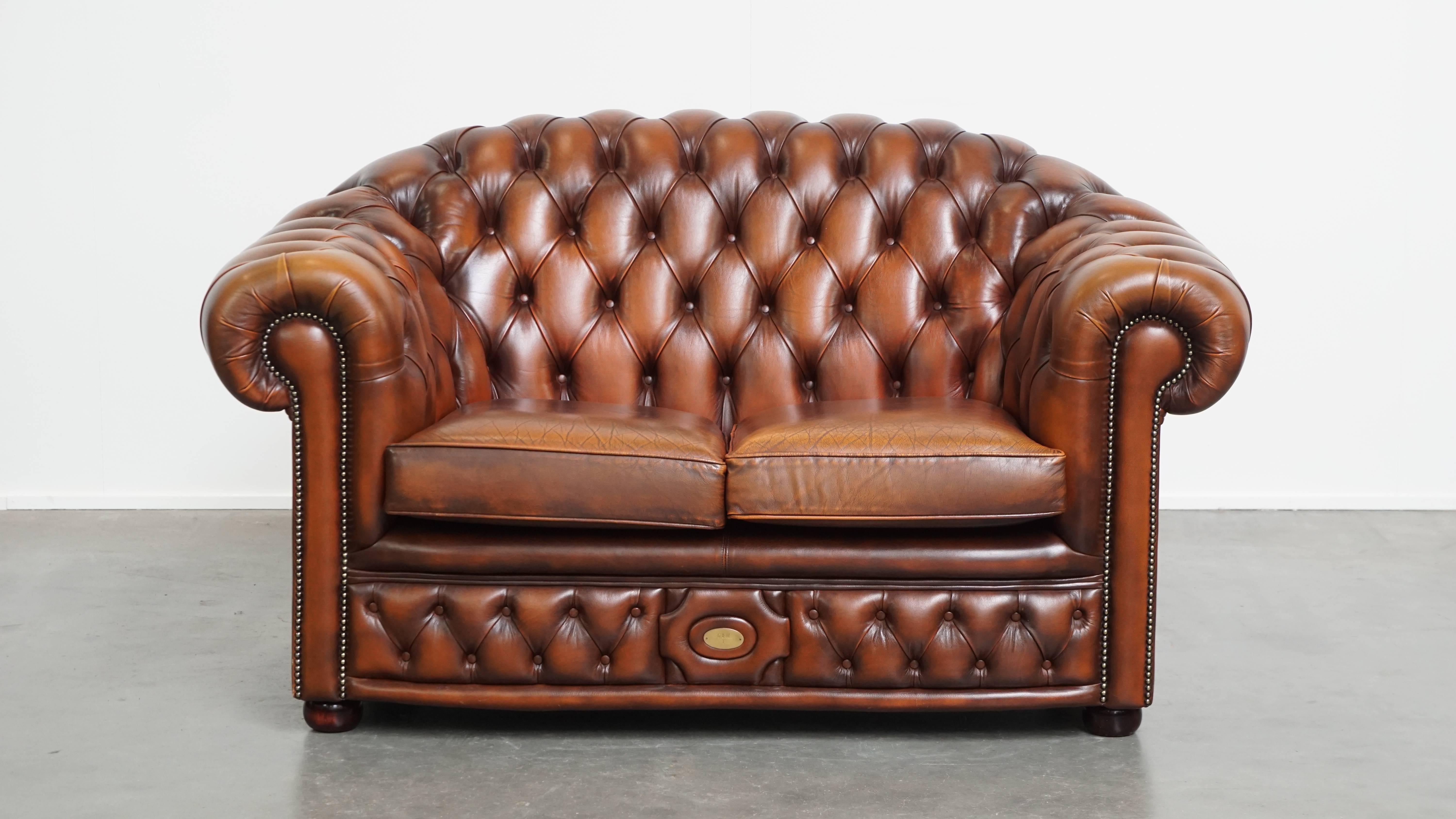 Offered: this beautiful and complete set of a 2.5-seater and 2-seater brown English cowhide leather Chesterfield sofa.
This stunning set, consisting of a lovely 2.5-seater and 2-seater Chesterfield sofa in brown cowhide leather, makes a great