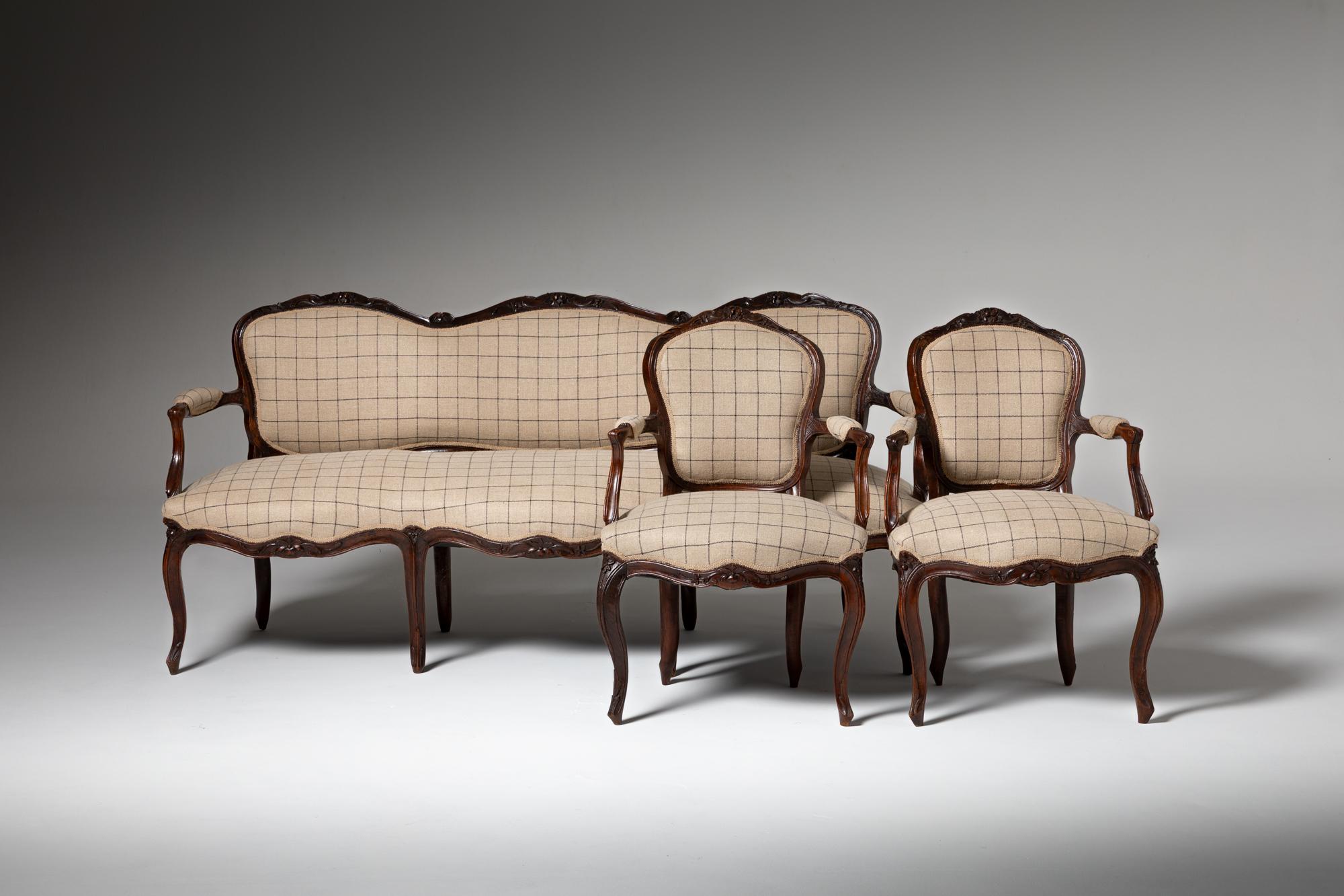 This elegant set, consisting of a canapé and two armchairs in the D. José style, exemplifies the refined craftsmanship of 18th-century Portuguese furniture. Made of finely carved walnut wood, the pieces display intricate scrollwork and delicate