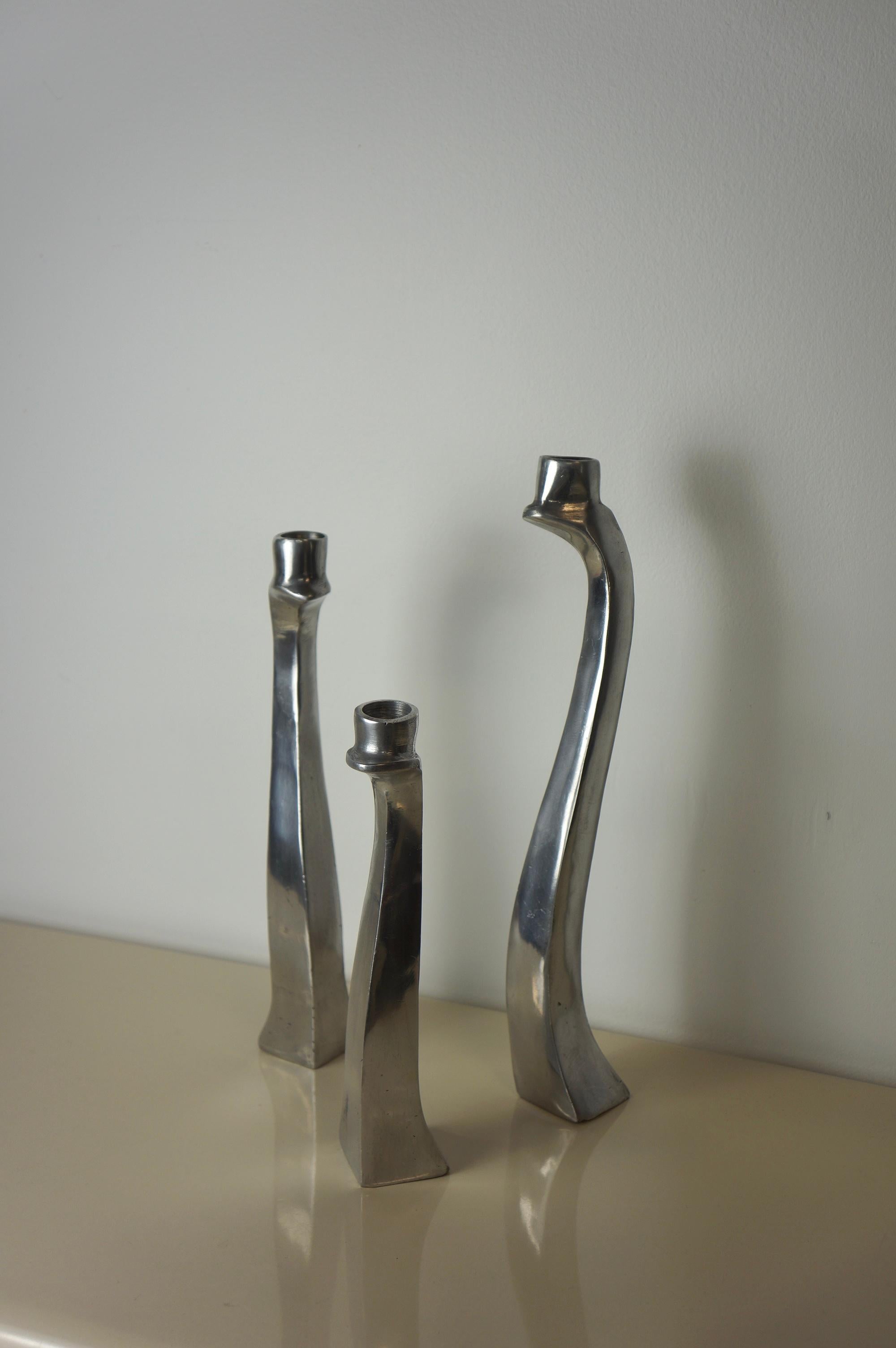 A set of three biomorphic polished aluminum candle holders. They’re made in the 1980s. This style of candle holders are attributed to Escapade Paris. These candle holders are free formed with a sculptural polished aluminum body. The set of three