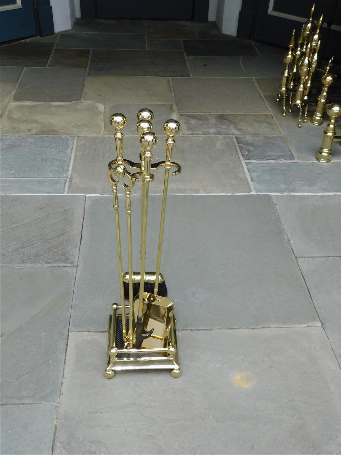 Set of American brass ball finial fire place tools on stand resting on a molded edge rail base with the original ball feet. Set consist of tong, poker, shovel, and brush. 19th Century.