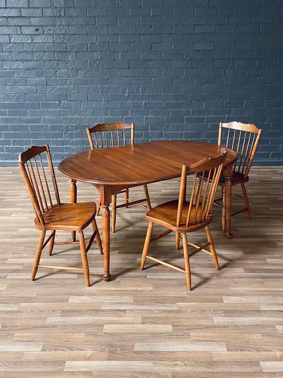Condition: Original Vintage Condition
Designer: L. Hitchcock Chair Co. 
Manufacturer: L. Hitchcock Chair Co. 

This dining set by L. Hitchcock exemplifies the American Colonial Revival style, crafted in Connecticut during the mid-20th century. The