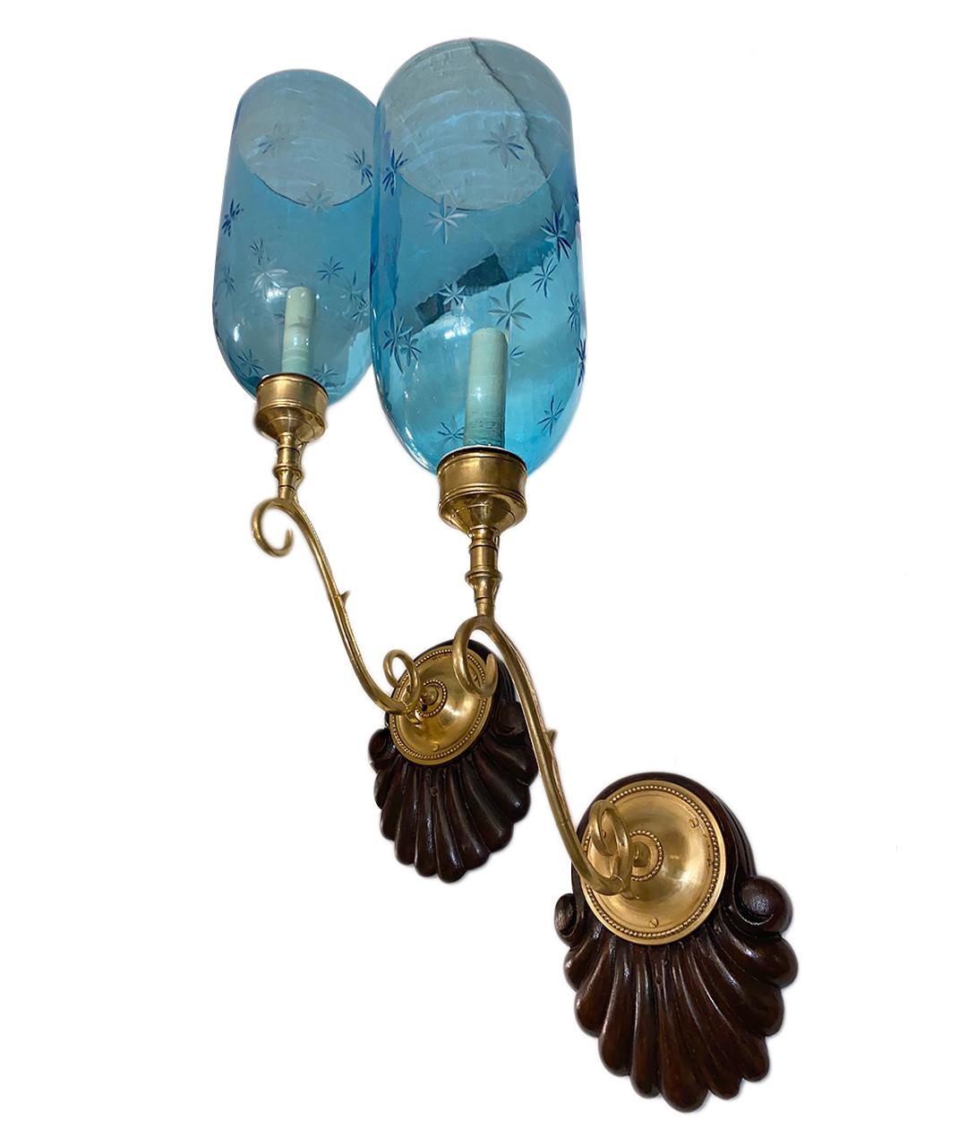 A set of four circa 1940's Anglo-Indian single-light sconces with carved wood backplates and etched blue glass hurricanes. Sold per pair.

Measurements:
Height: 24