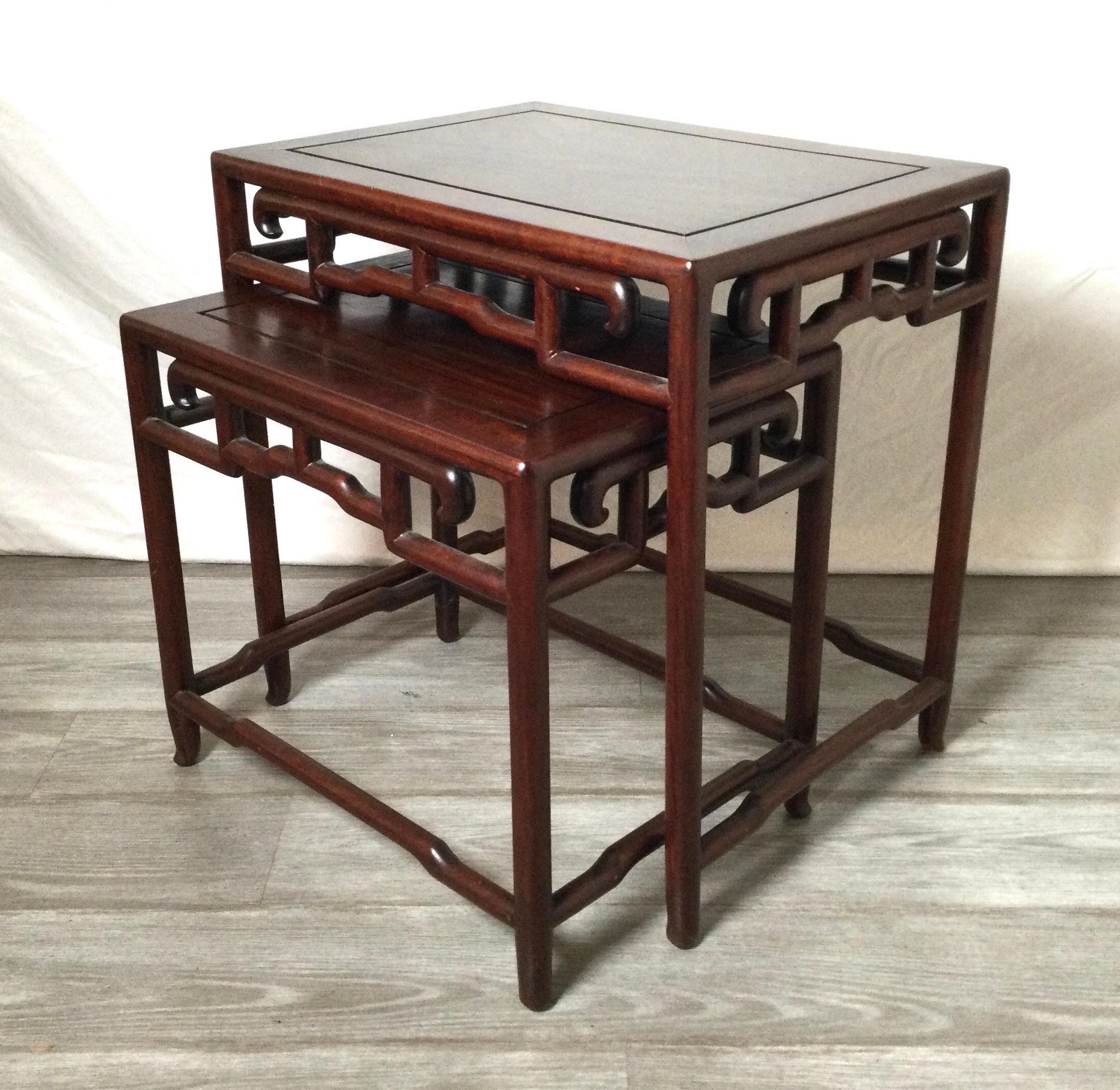 A set of 2 antique Chinese hongmu hand carved nesting tables. The smaller that fits neatly into the larger table for easy access. 22 wide, 22.25 high, 16 deep.