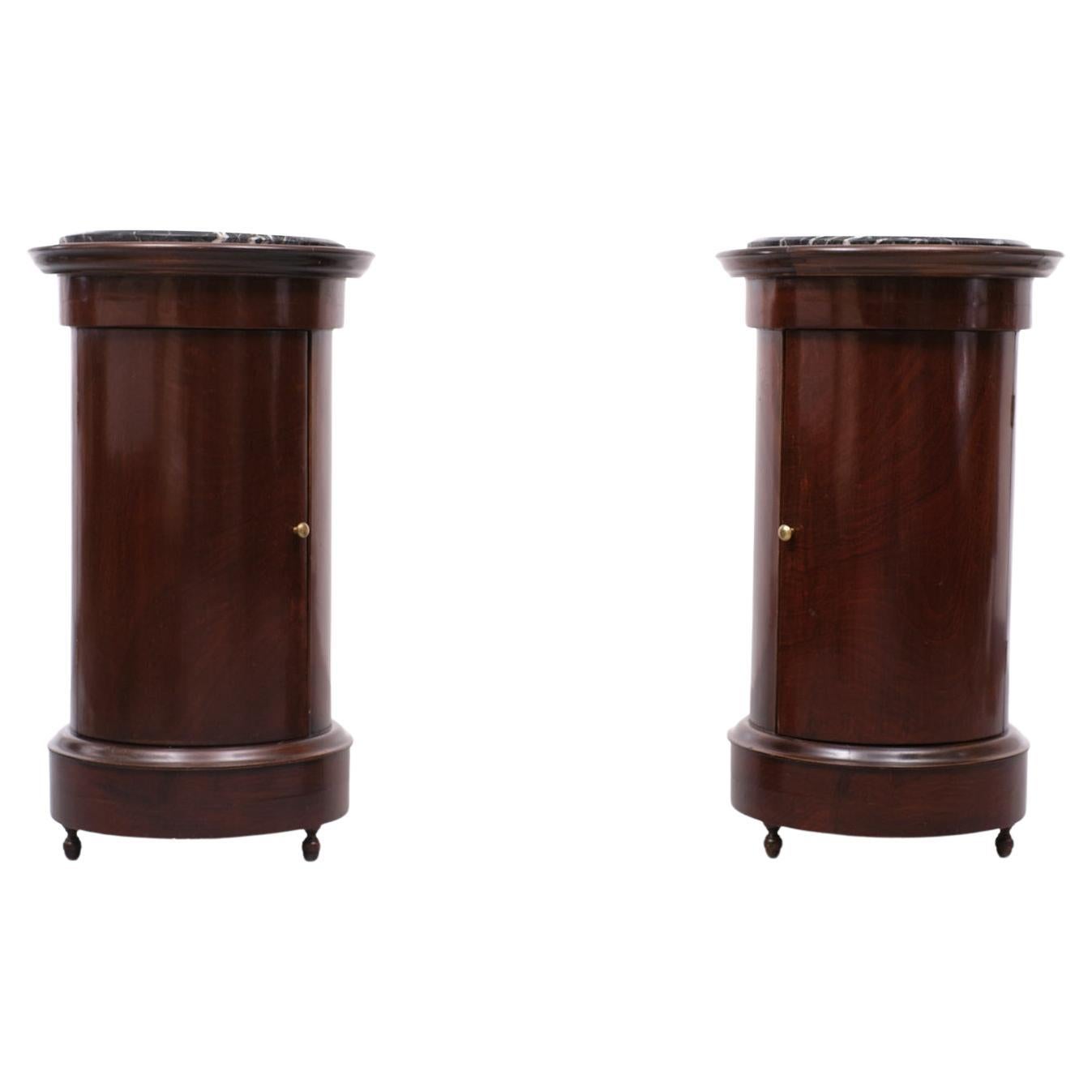 Beautiful and very rare set of Antique cylindrical mahogany nightstands, comes with
veined Black Marble tops. One shelve each, brass knobs. Comes in a warm dark Brown Red color. Victorian England 1880s
Overall in a good condition. One repair on